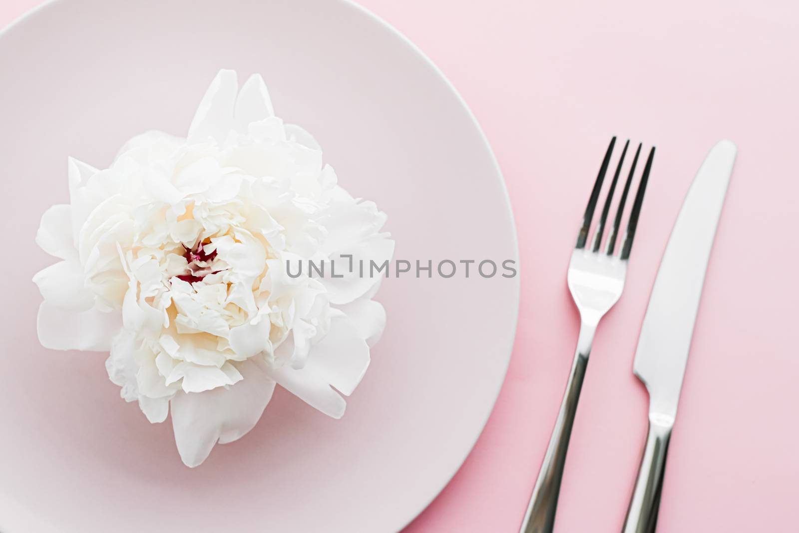 Dining plate and cutlery with peony flower as wedding decor set on pink background, top tableware for event decoration and dessert menu by Anneleven