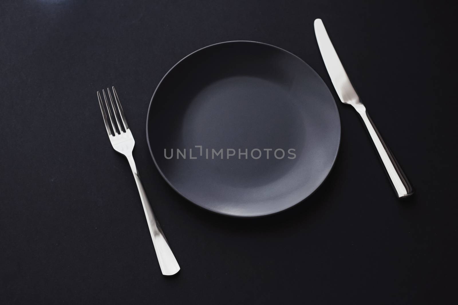 Empty plates and silverware on black background, premium tableware for holiday dinner, minimalistic design and diet by Anneleven