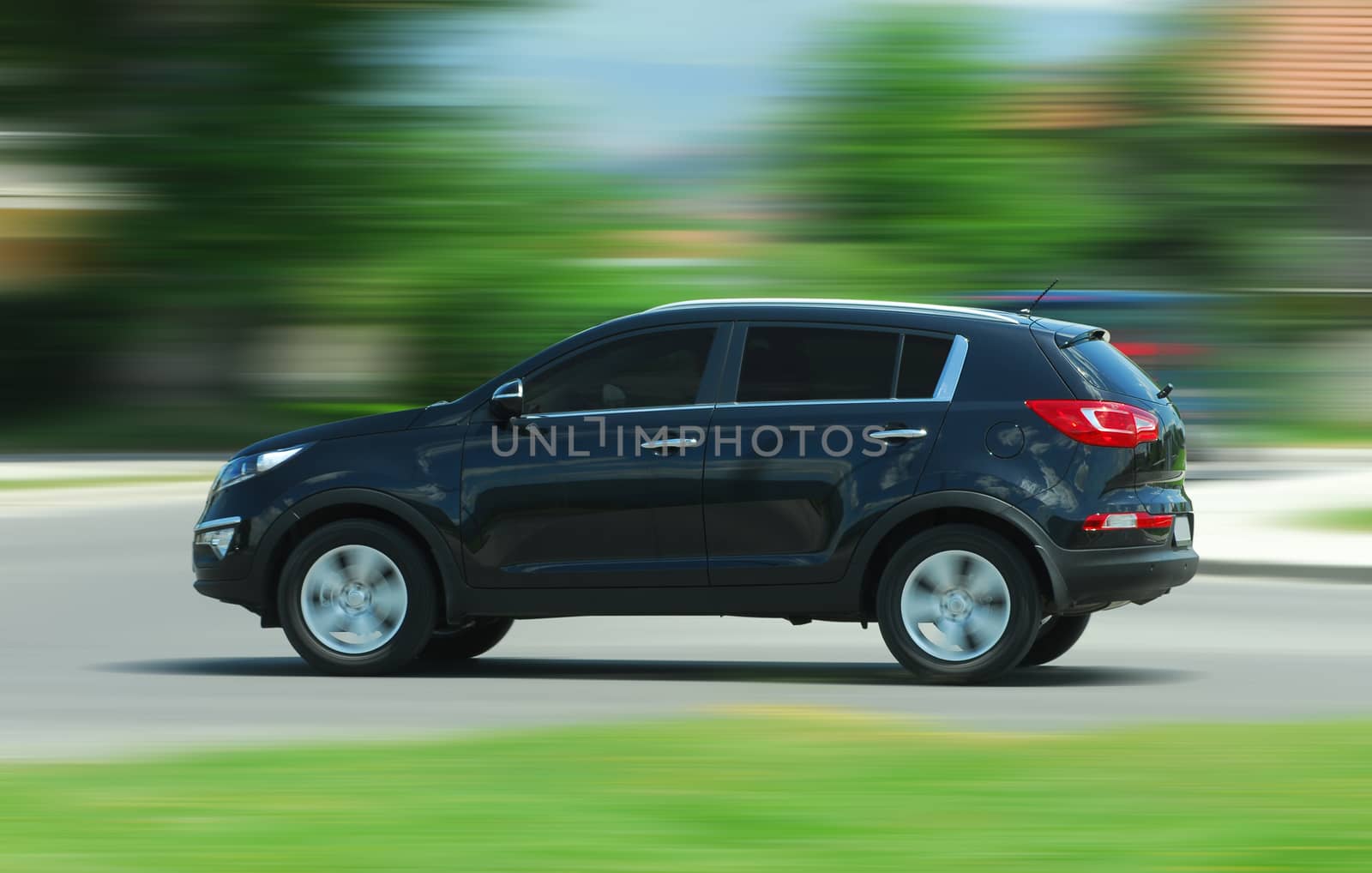 A panning shot of a speeding SUV