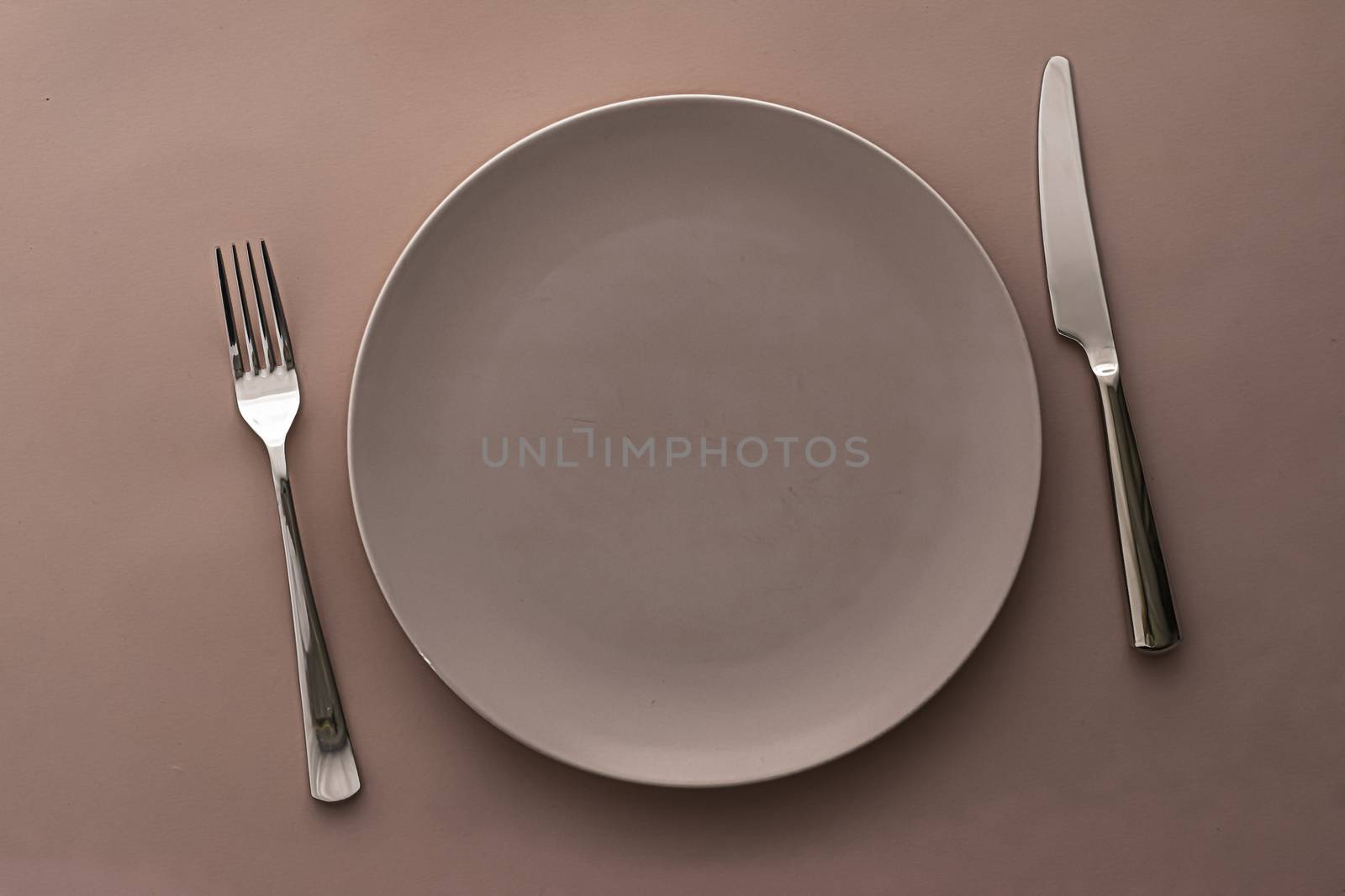 Empty plate and cutlery as mockup set on brown background, top tableware for chef table decor and menu branding design