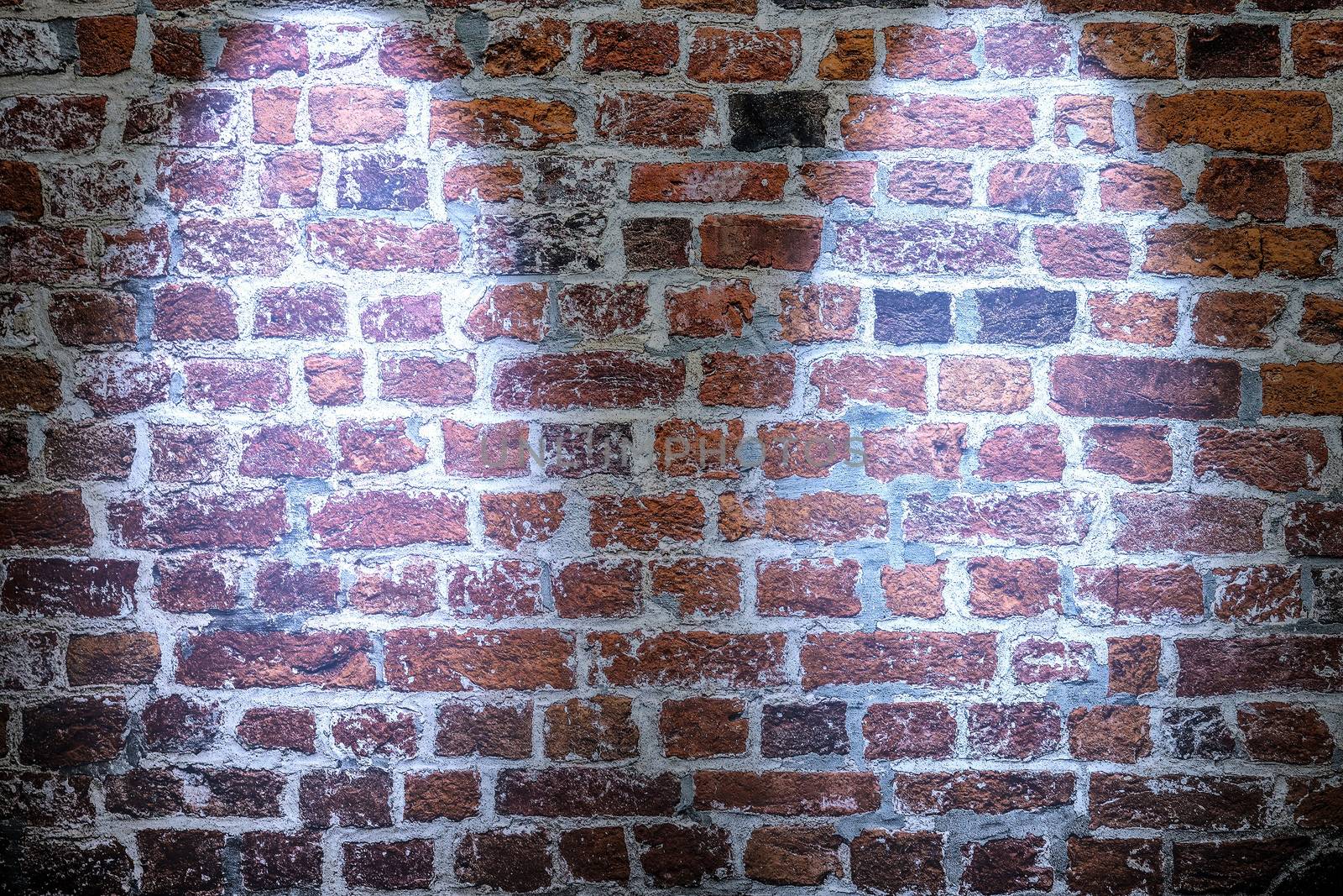 Aged and weathered brick wall textures with bright spotlight illumination