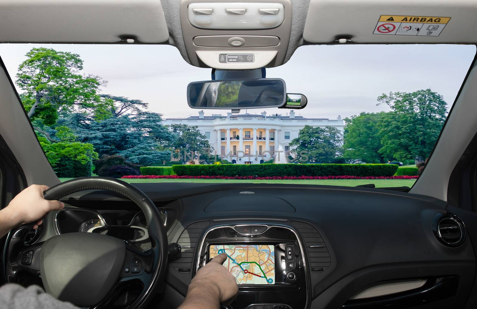 Driving a car while using the touch screen of a GPS navigation system towards the White House, Washington DC, USA