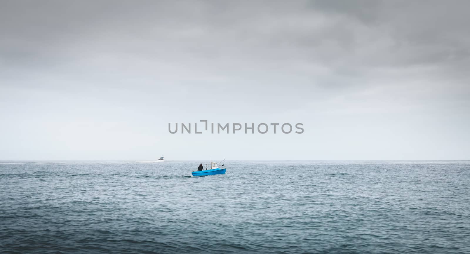 Port Joinville, France - September 18, 2018: Small blue fishing boat sailing on the coast near Port Joinville harbor on Yeu island on a summer day