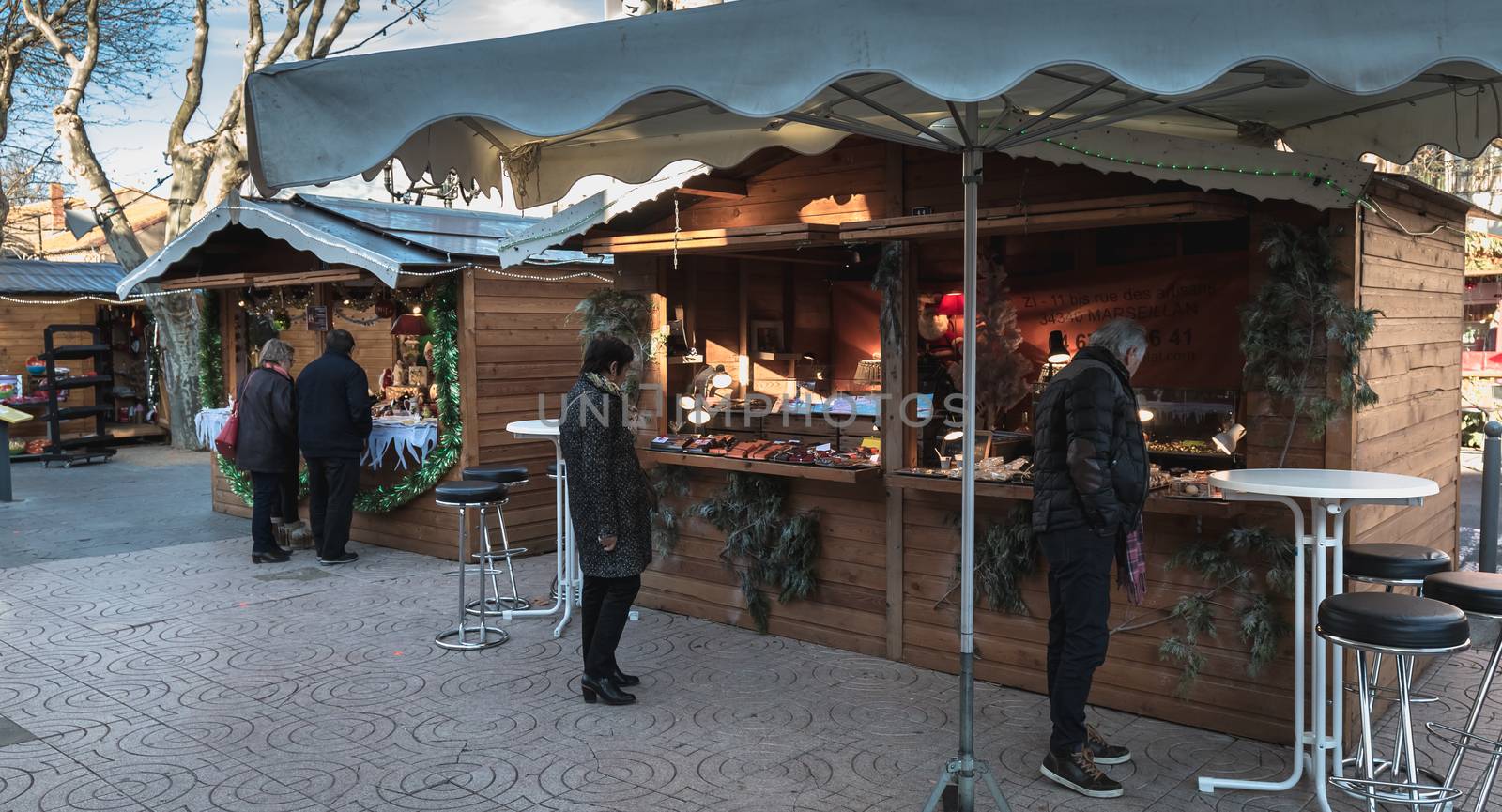 Marseillan, France - December 30, 2018: Street atmosphere in the Christmas market of the city where people walk on a winter day