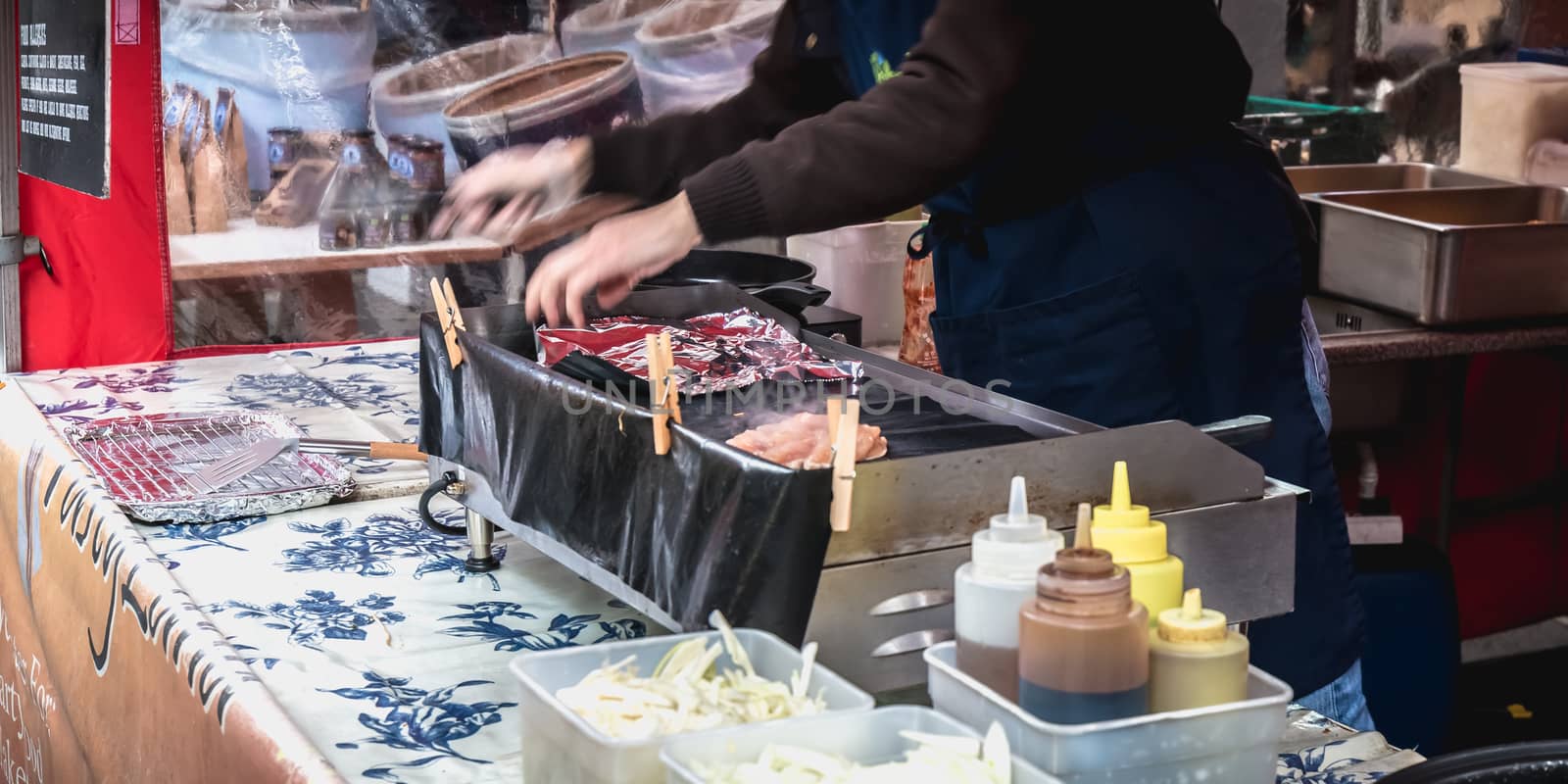 Dublin, Ireland - February 16, 2019: Live food stall where a cook prepares a meal in front of his client in the Temple Bar district on a winter day