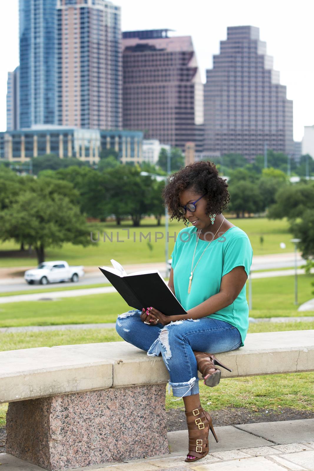 Beautiful African American woman reading a book, Austin, Texas background