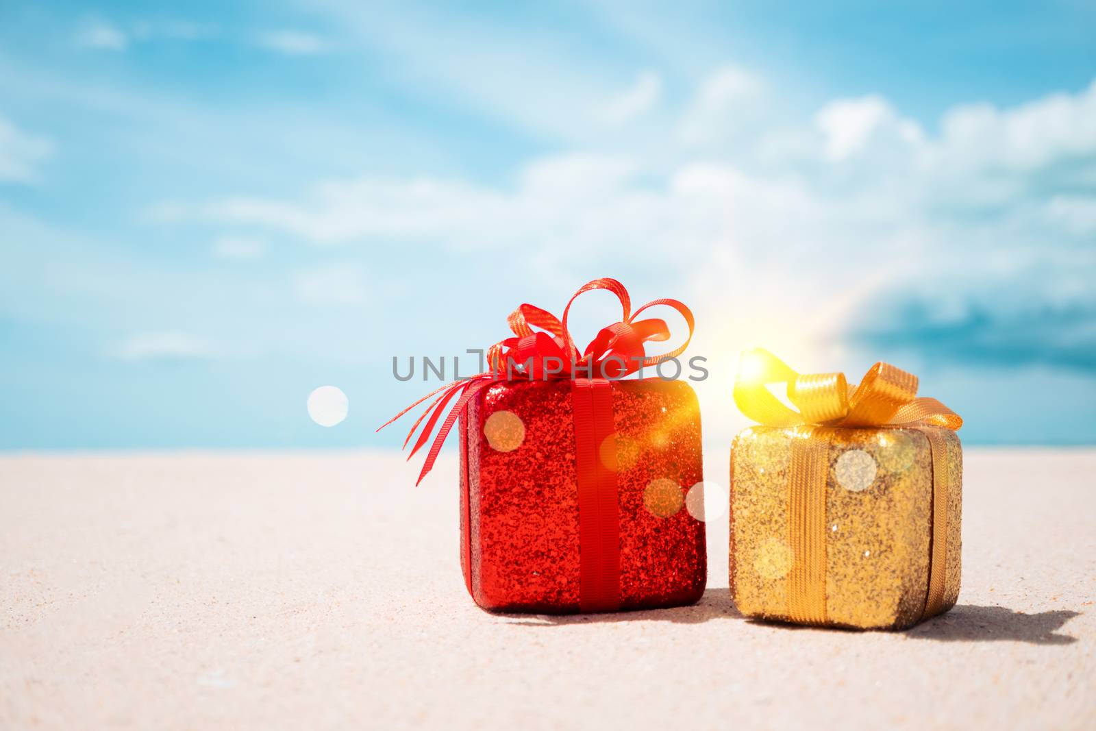 Gift boxes on sandy beach. Hot tours or holiday vacation concept with summer sea background.