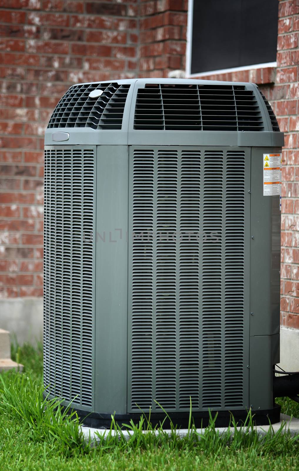 Air conditioner close up in front of brick wall