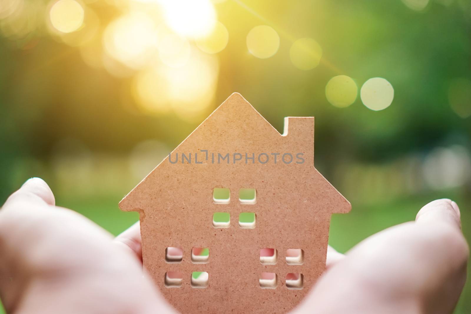 Copyspace model of a little house that woman holds it background. by Suwant