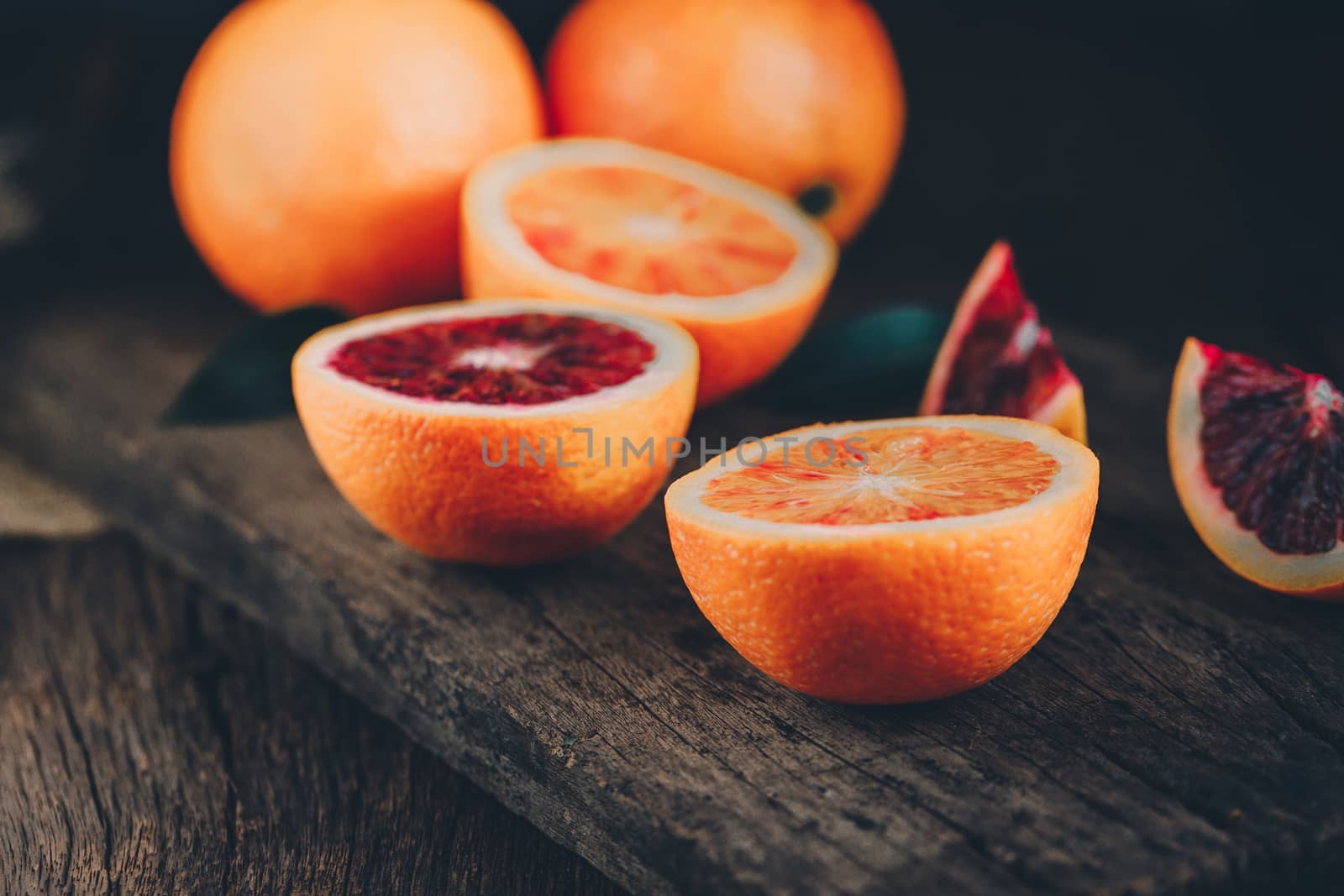 Sliced Sicilian Blood oranges fruits over old dark wooden backgr by freedomnaruk