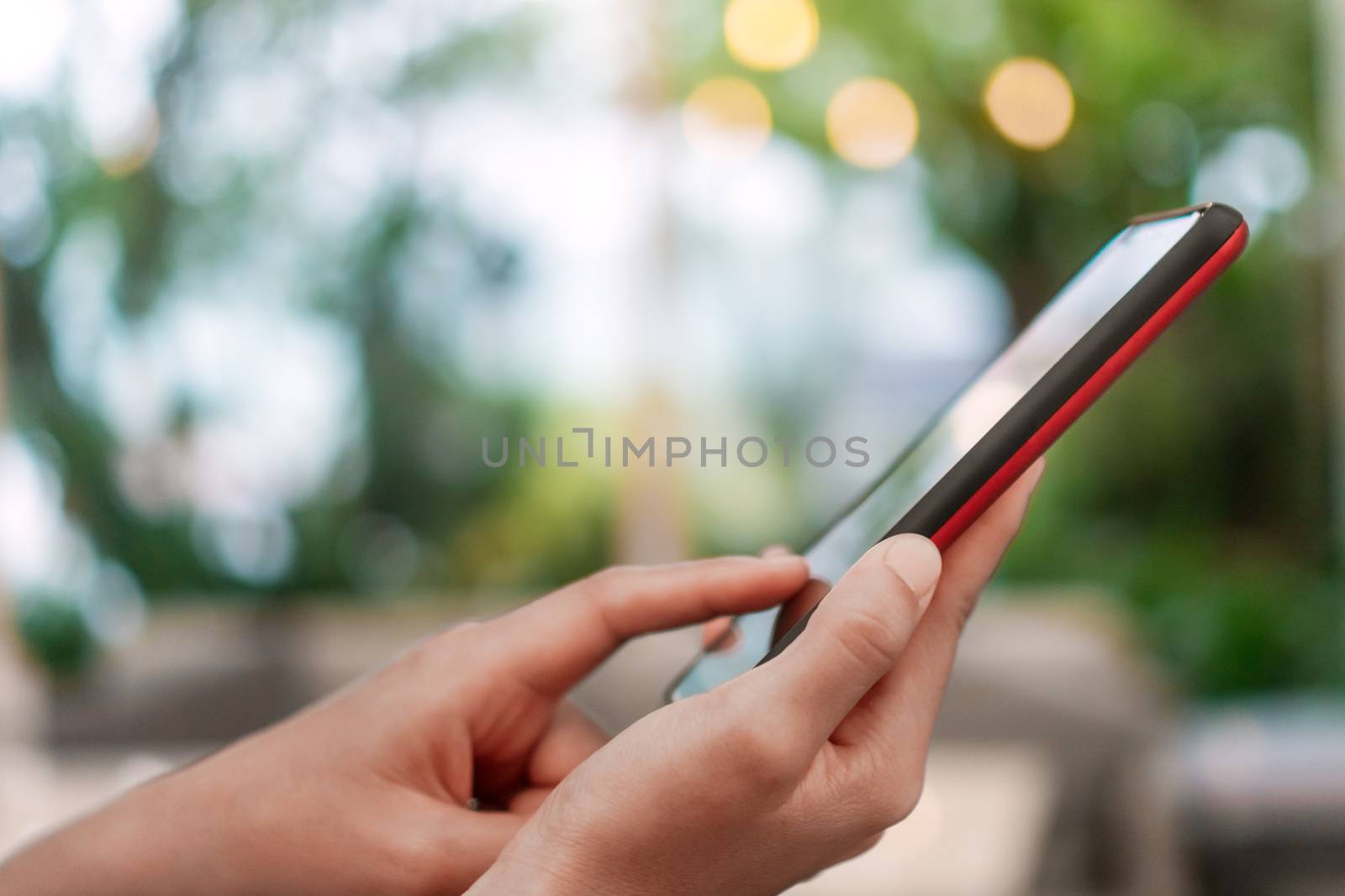 Woman hand use smartphone to do work business, social network, communication in public cafe work space area.