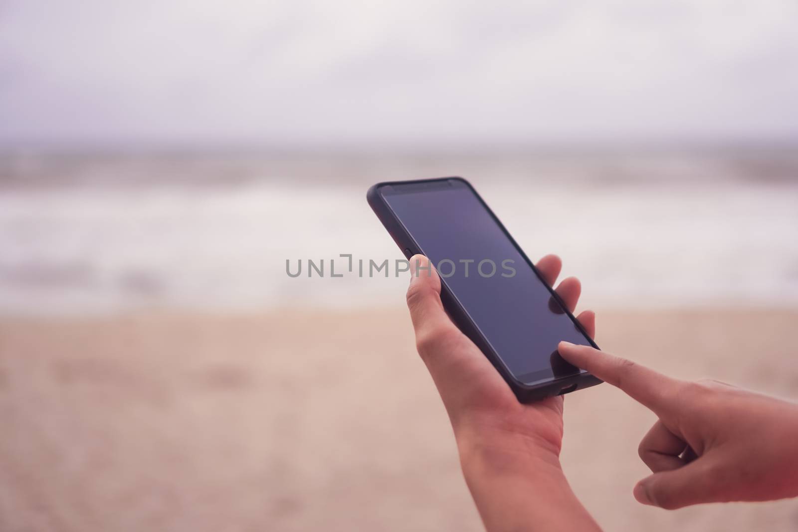 Woman hand use smartphone to do work business, social network, communication in public cafe work space area.