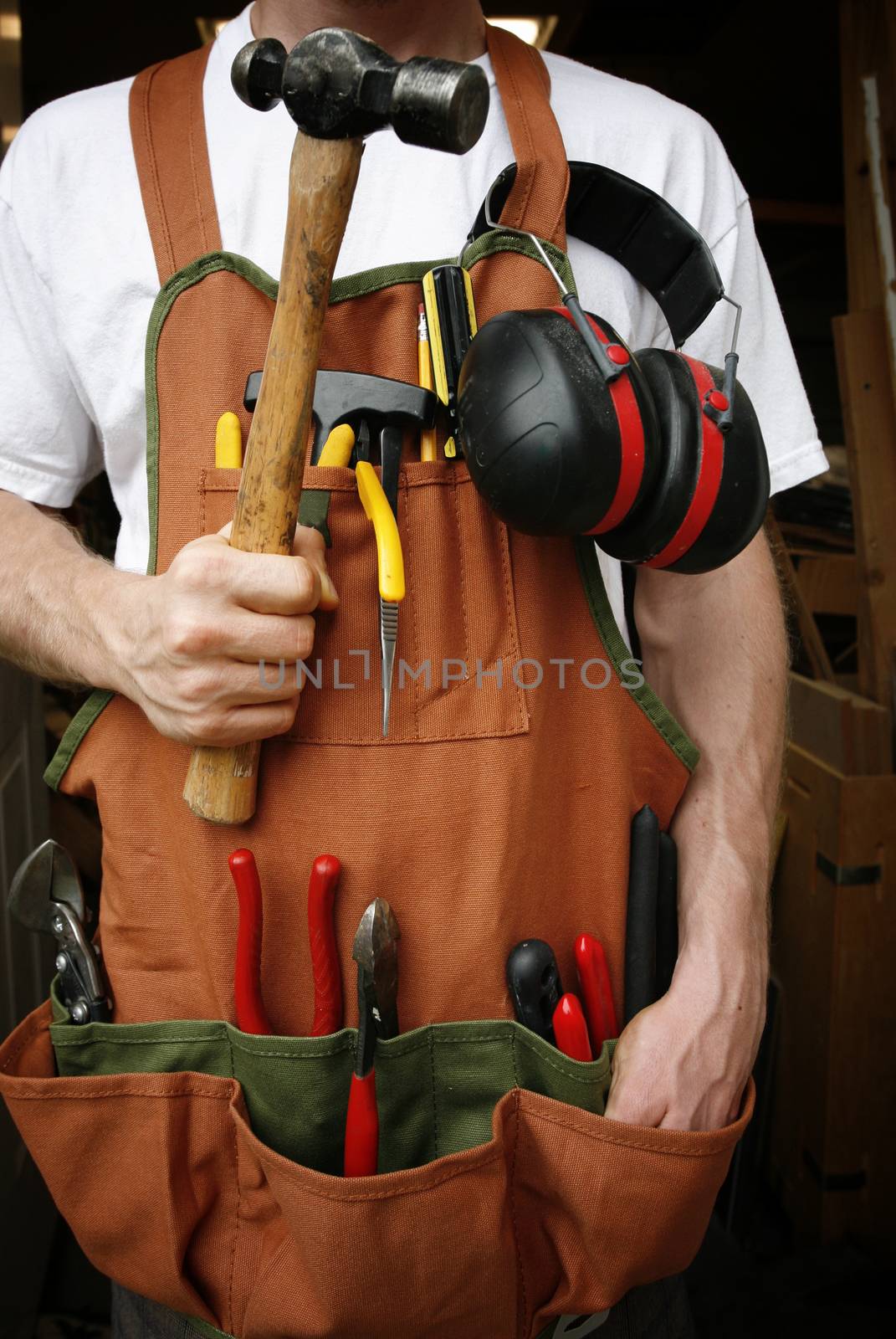 Handy man in front of work shop holding hammer