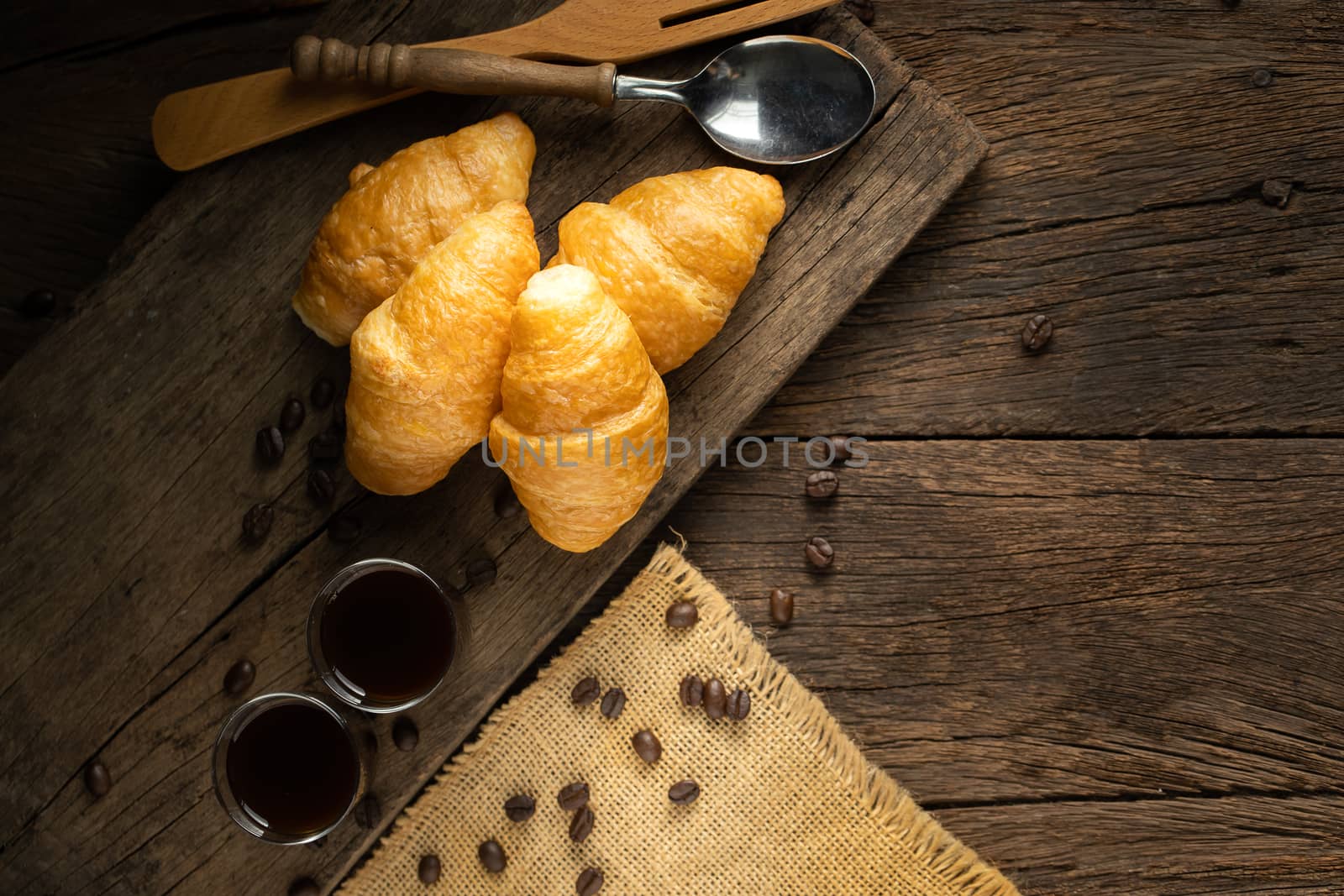 Coffee and croissants on the wooden background, top view