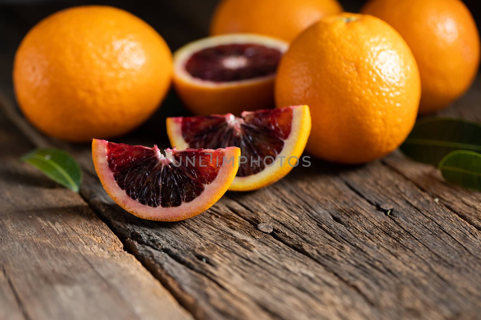 Sliced Sicilian Blood oranges fruits over old dark wooden backgr by freedomnaruk