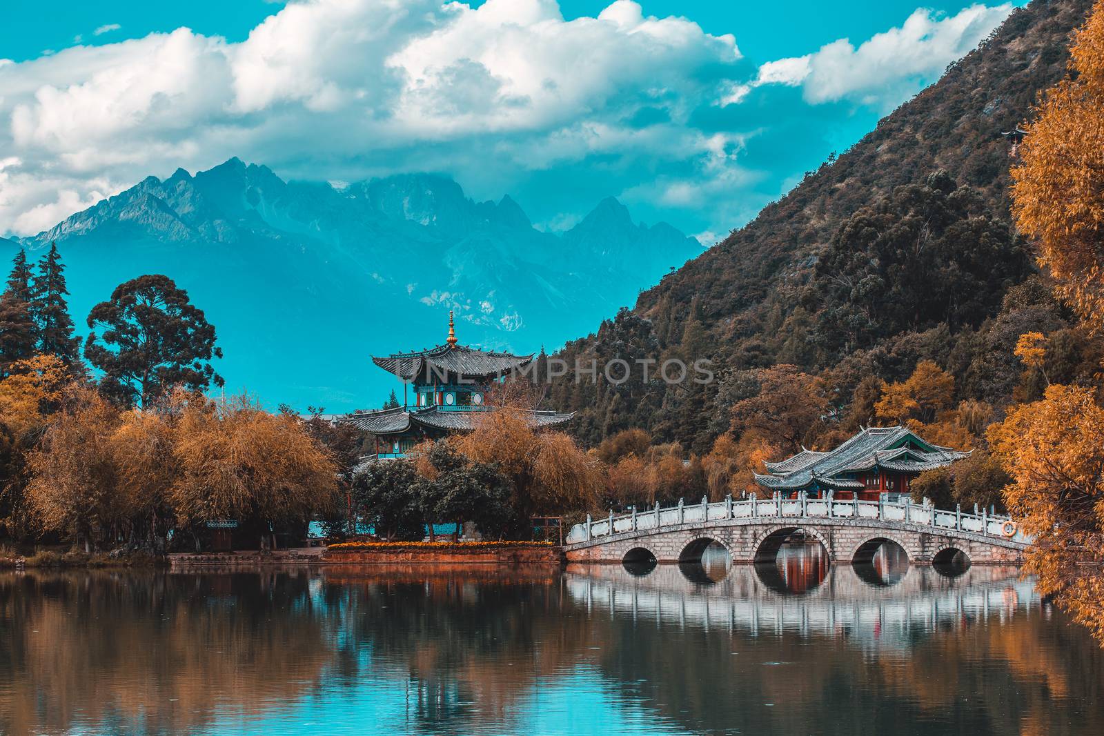 Beautiful view of the Jade Dragon Snow Mountain and the Suocui Bridge over the Black Dragon Pool in the Jade Spring Park, Lijiang, Yunnan