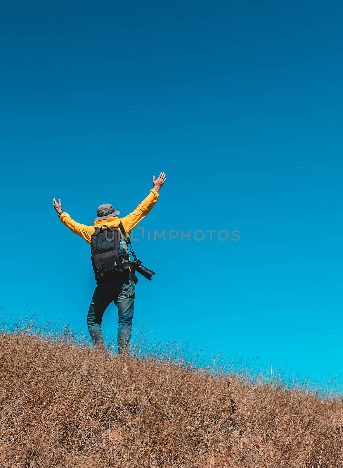 Silhouette of man hold up hands on the peak of mountain
