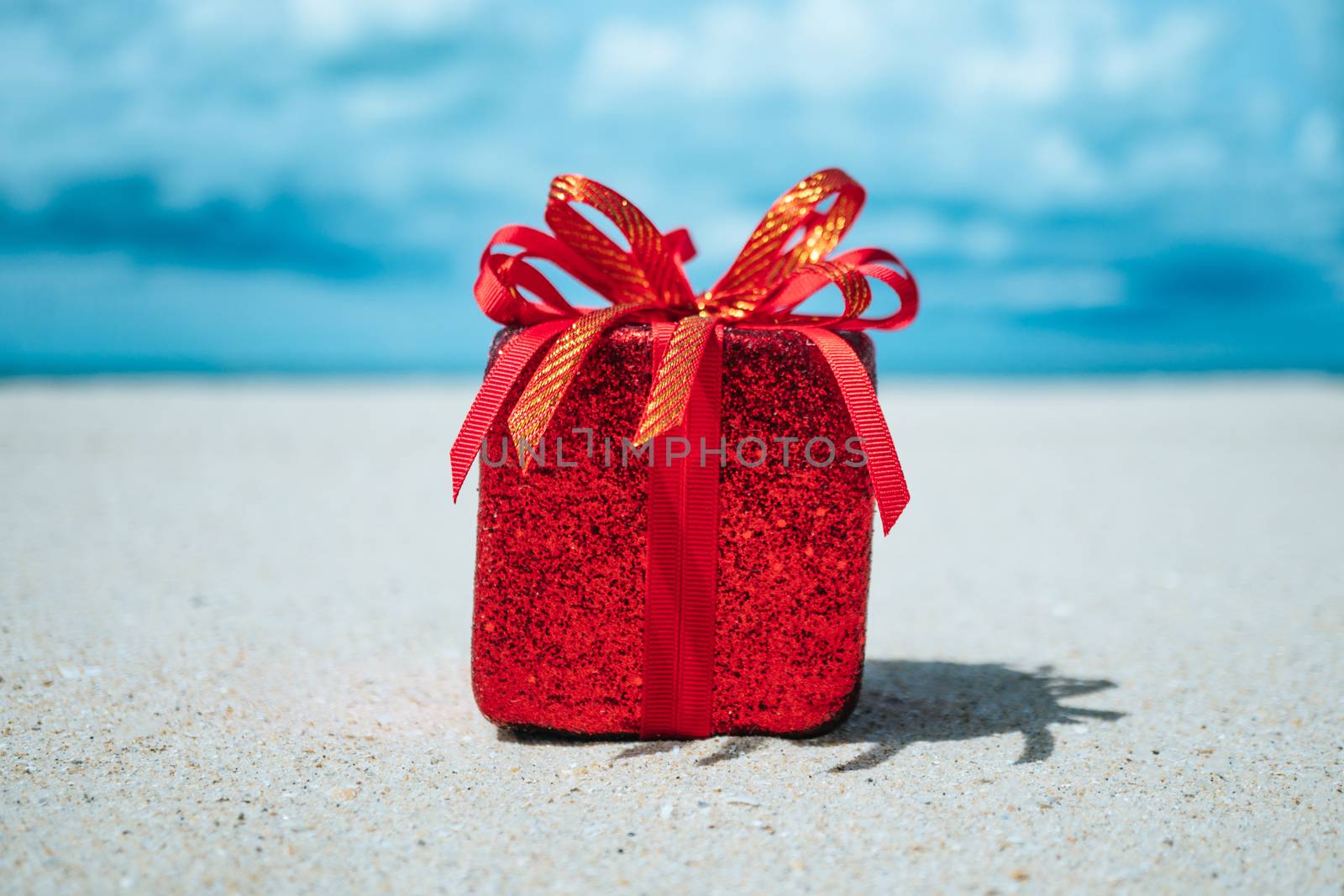 Gift boxes on sandy beach. Hot tours or holiday vacation concept with summer sea background.