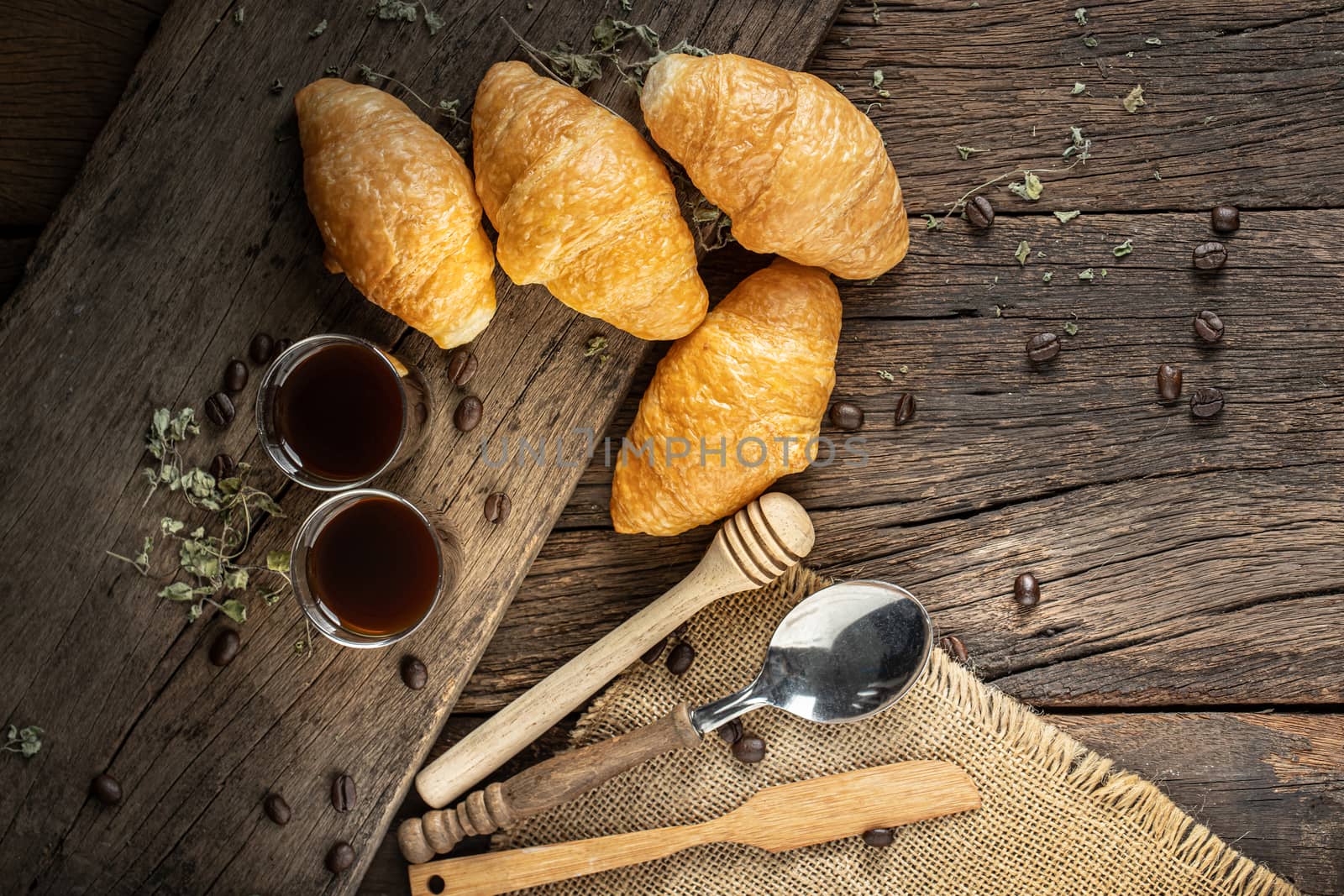 Coffee and croissants on the  wooden background, top view