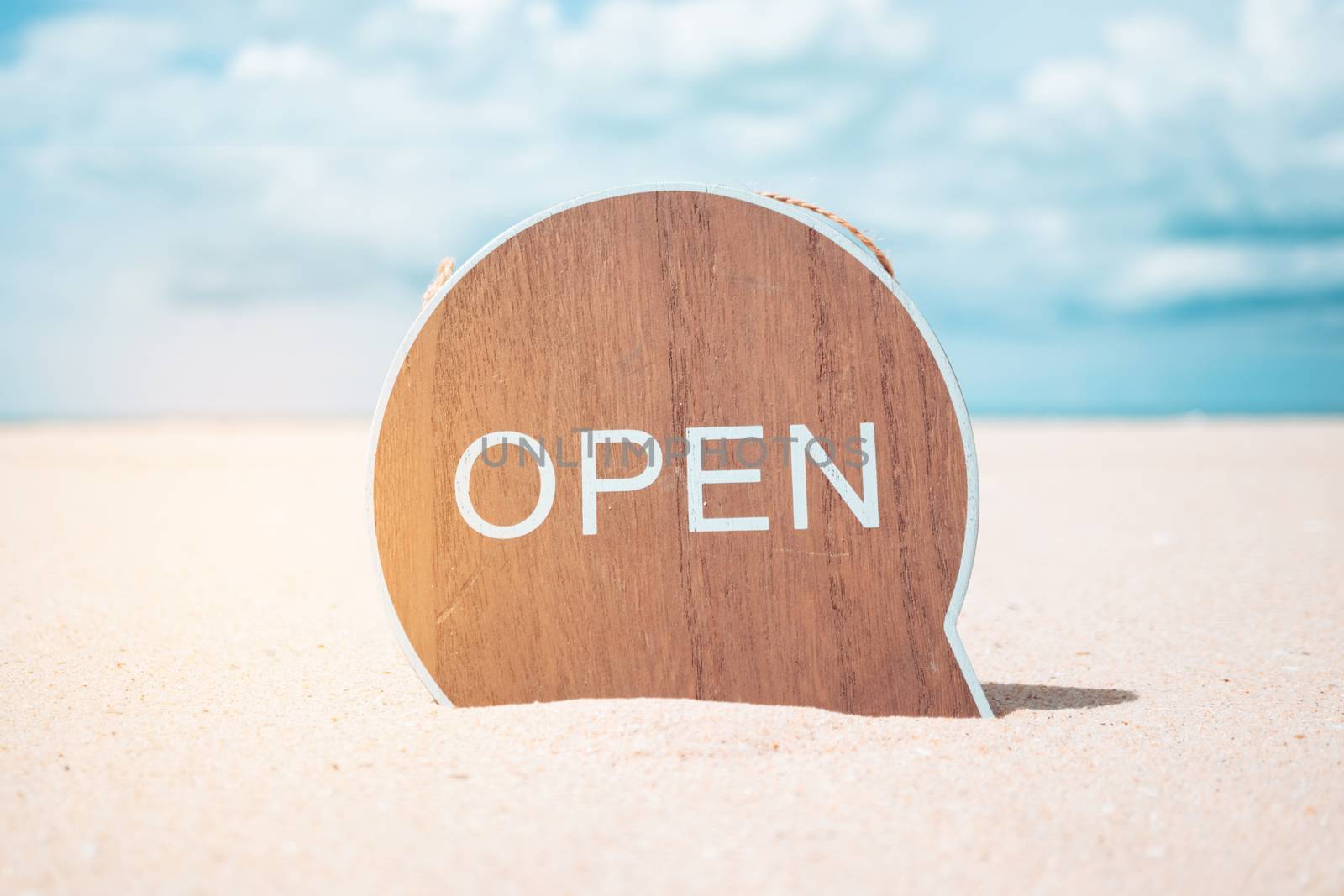 Now open sign board stand on sand summer beach background metaphor to time to travel relax tourism season with copyspace background.