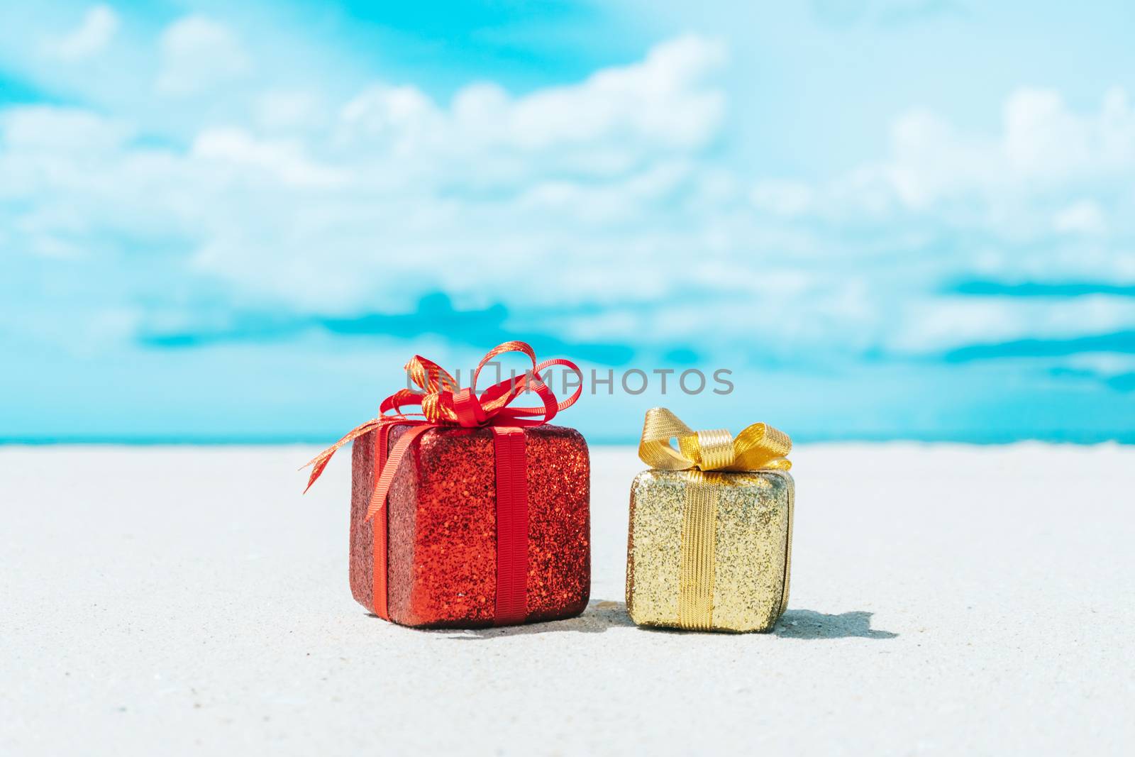 Gift boxes on sandy beach. Hot tours or holiday vacation concept with summer sea. by Suwant