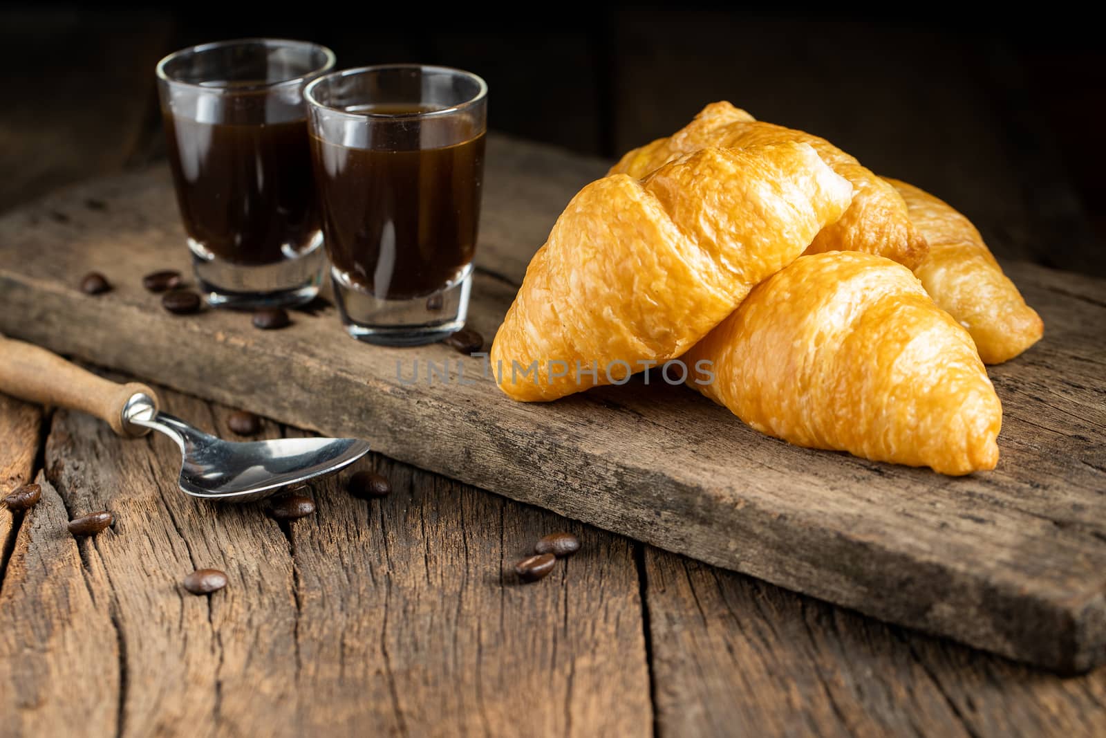 Coffee and croissants on the wooden background, top view
