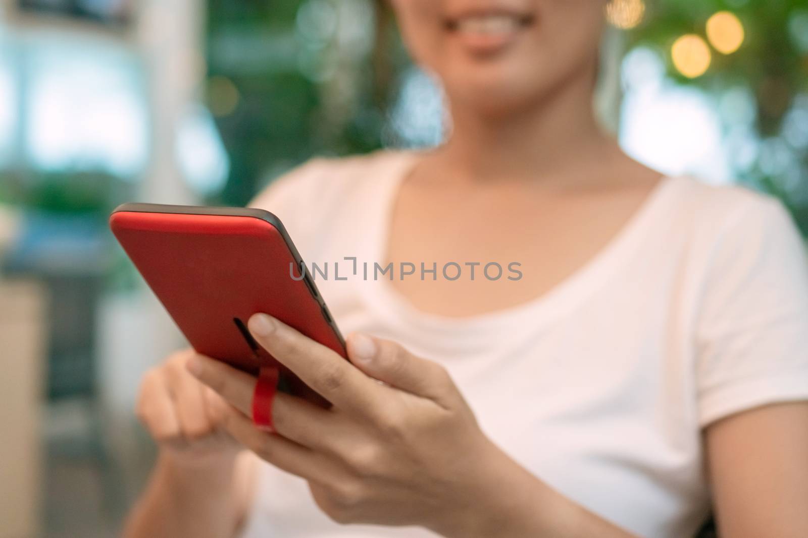 Woman hand use smartphone to do work business, social network, communication in public cafe work space area.