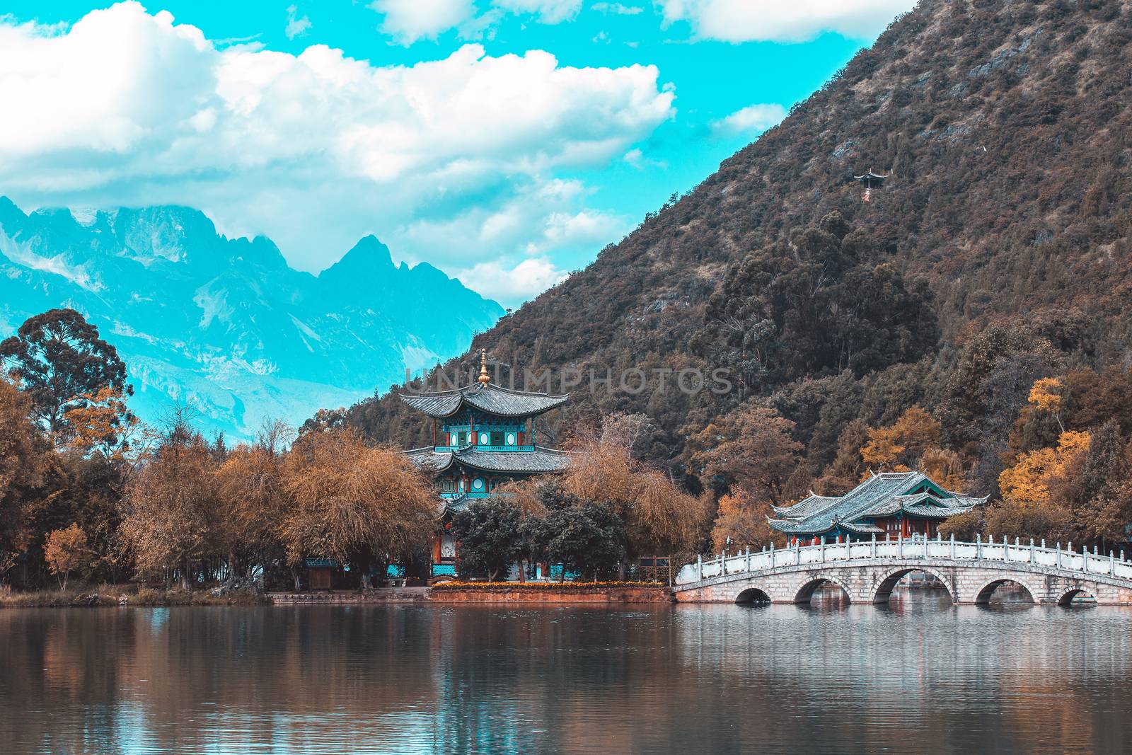 Beautiful view of the Jade Dragon Snow Mountain and the Suocui Bridge over the Black Dragon Pool in the Jade Spring Park, Lijiang, Yunnan
