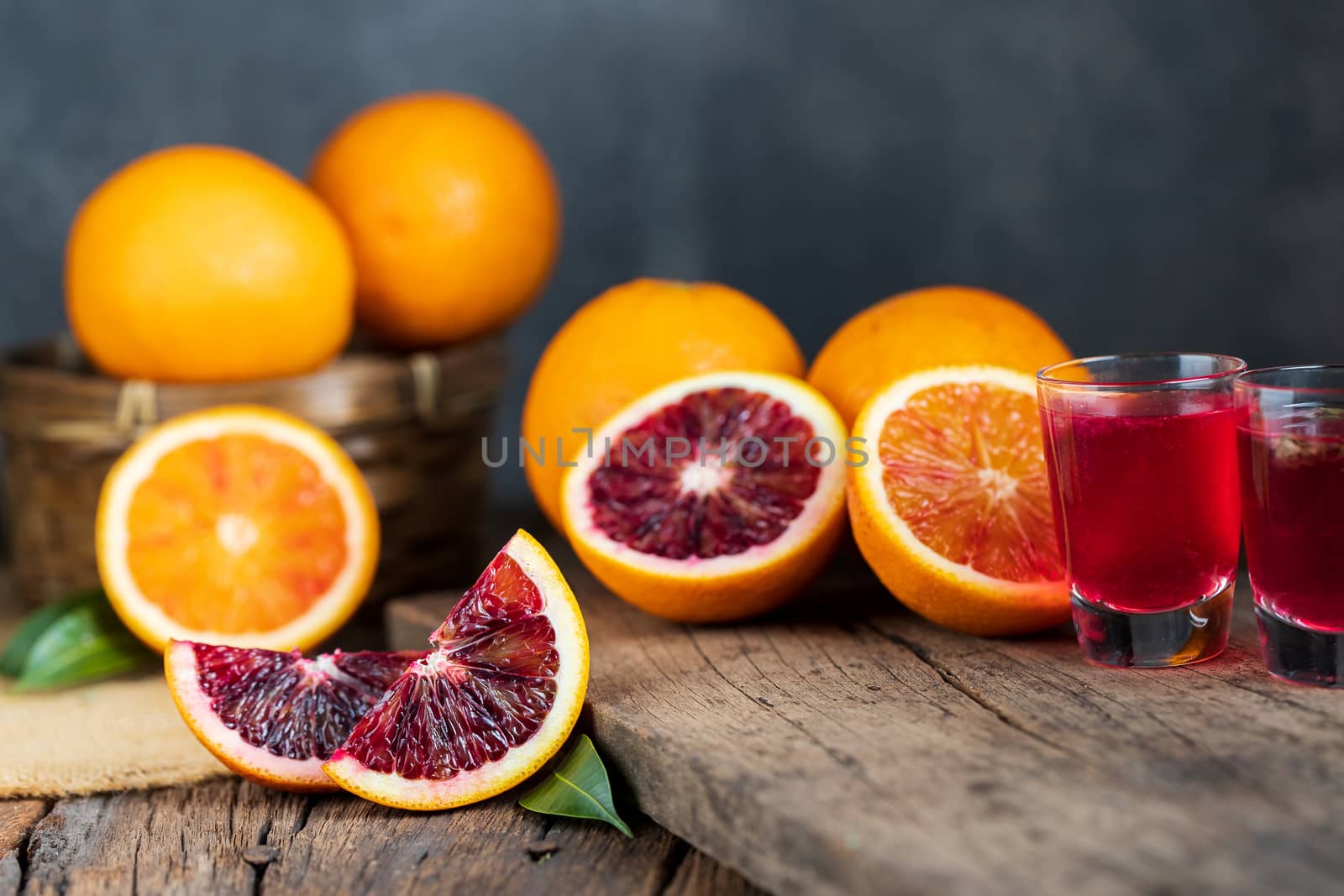 Sliced Sicilian Blood oranges fruits over old dark wooden background. Top view.