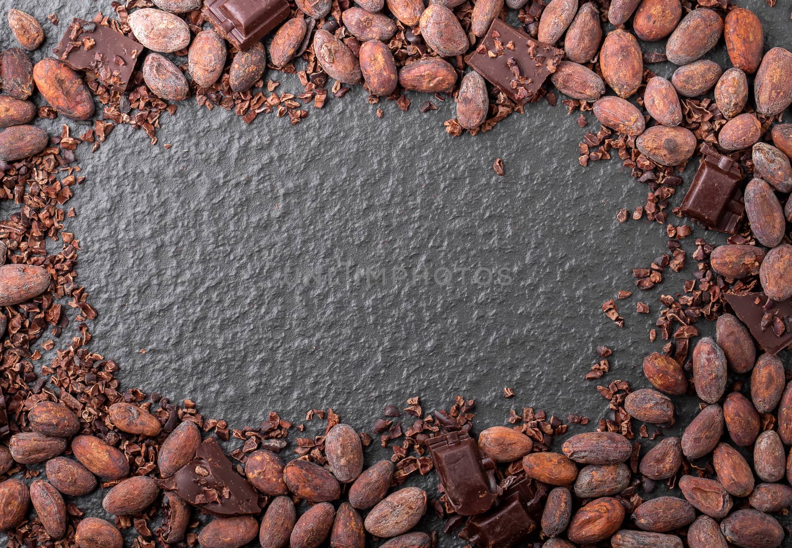 Cocoa beans and cocoa pod on a wooden surface.