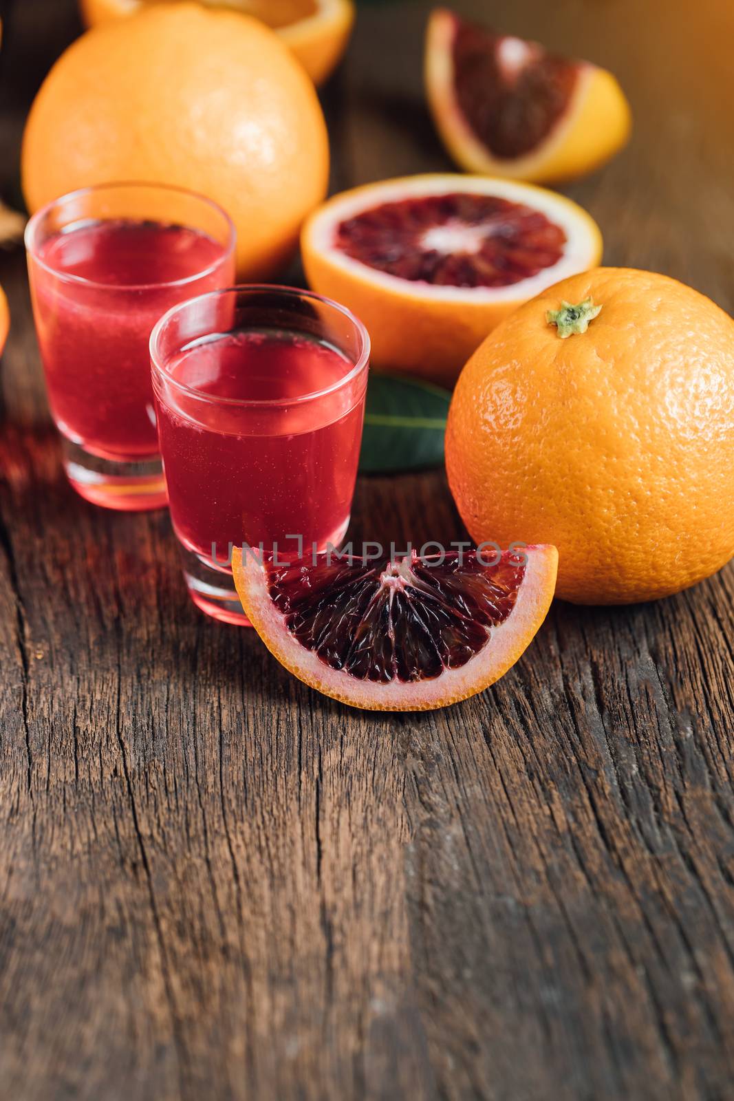 Sliced Sicilian Blood oranges fruits over old dark wooden background. Top view.