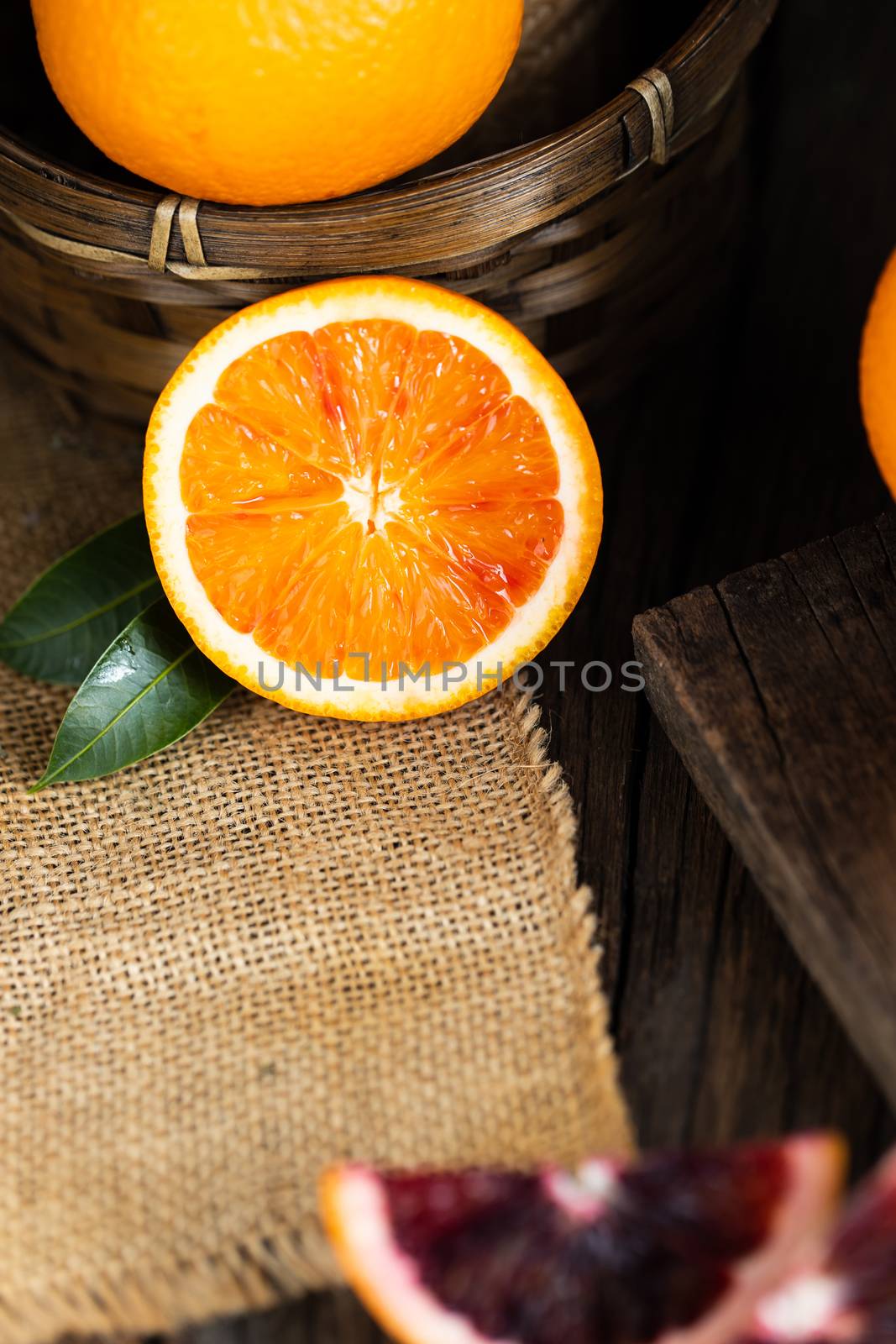 Sliced Sicilian Blood oranges fruits over old dark wooden backgr by freedomnaruk