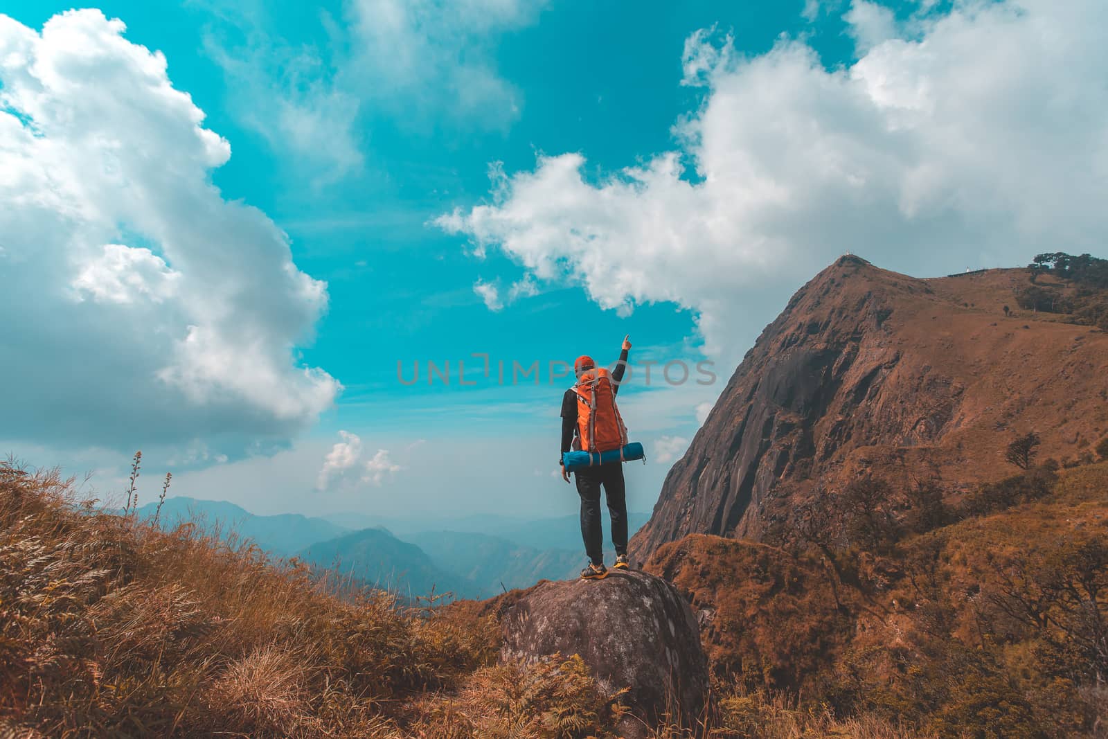 Silhouette of man hold up hands on the peak of mountain,success  by freedomnaruk