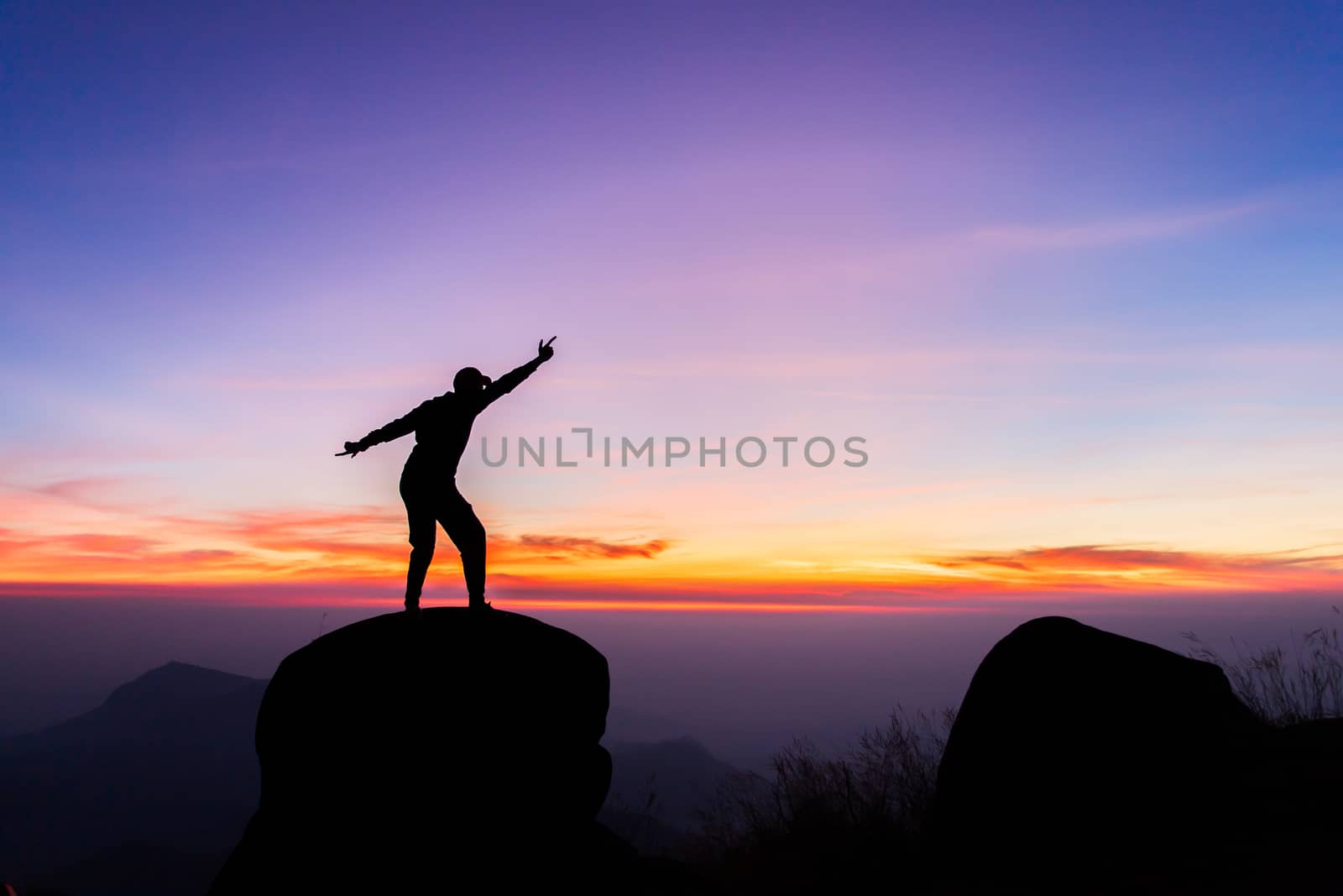 travels Silhouette on the peak of mountain,success concept by freedomnaruk