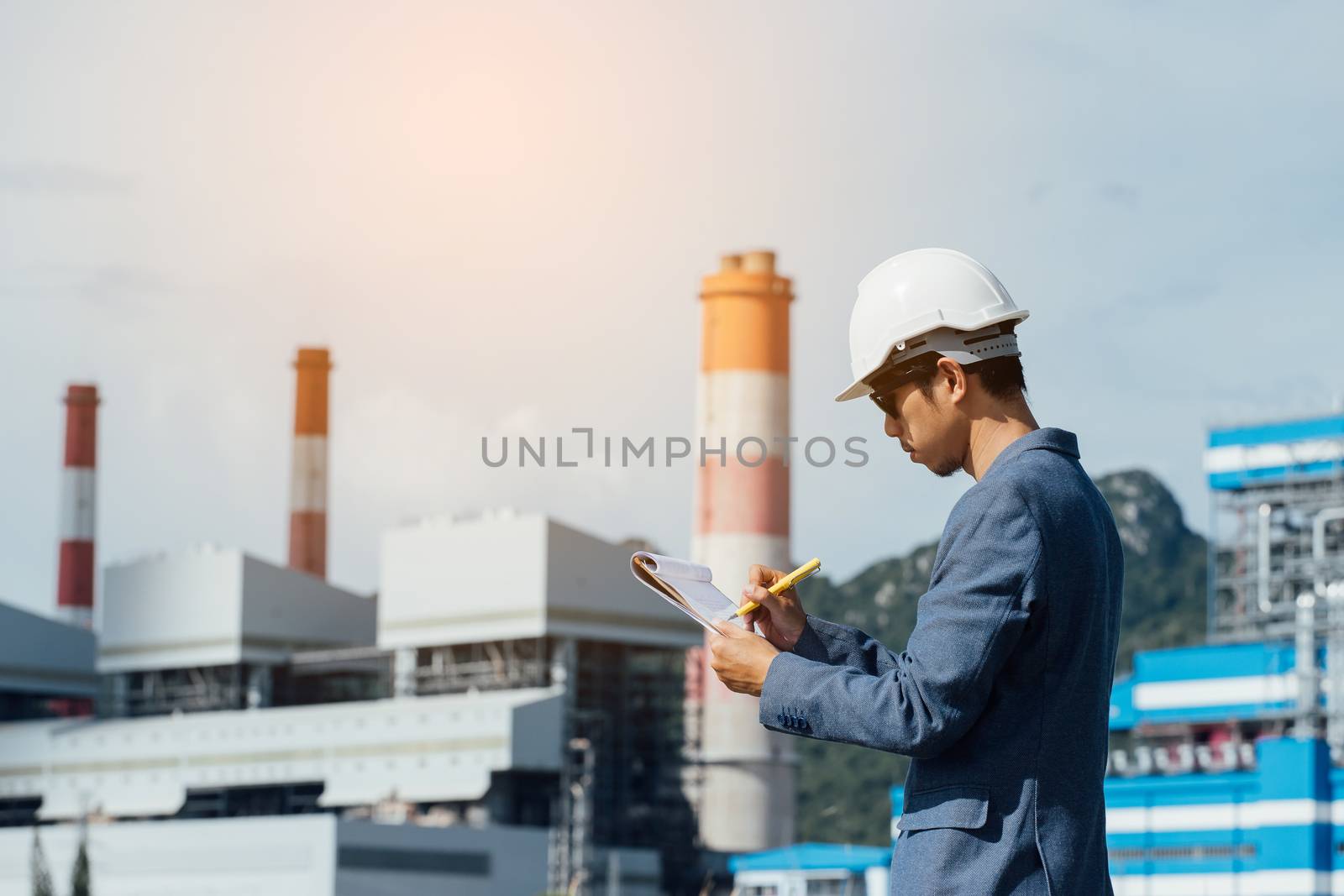 Engineer with a coal power plant in the background, Thailand by freedomnaruk