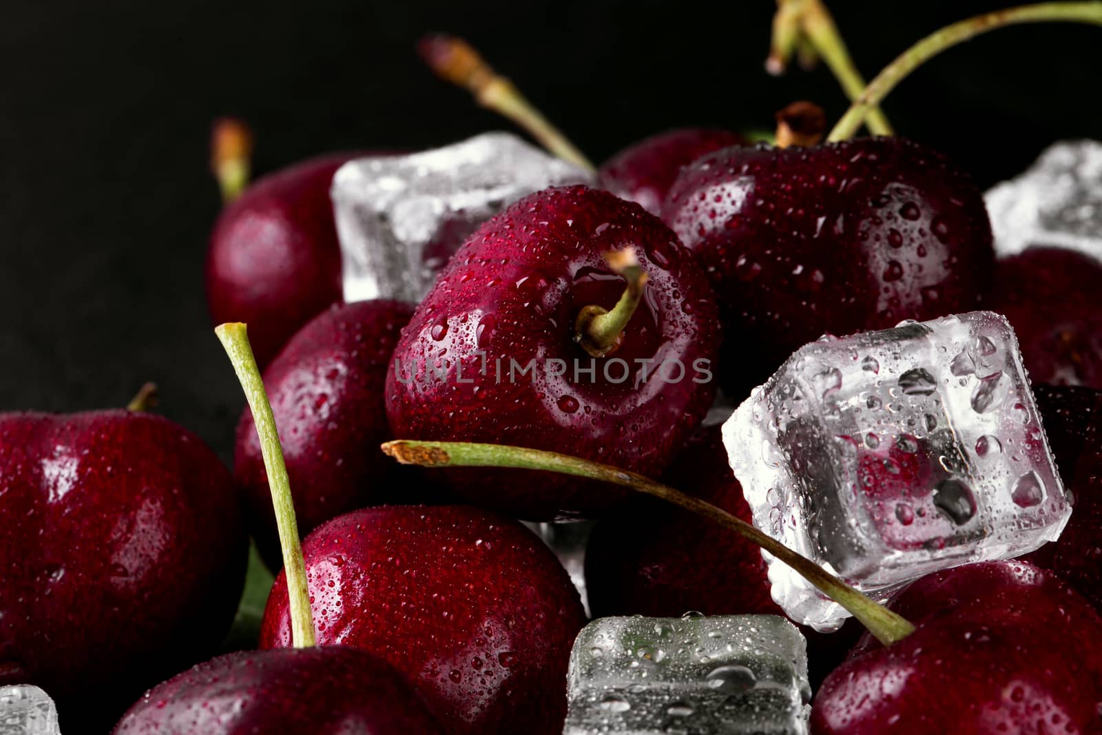 Close up of pile of ripe cherries with stalks and leaves. by freedomnaruk