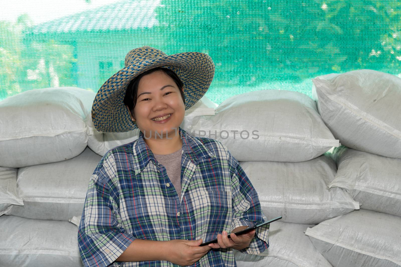 Asian woman smart farmer agriculturist happy at a Fertilizer composting plant with Organic Fertilizer, Compost (Aerobic Microorganisms) from animal waste for use in the organic agriculture industry