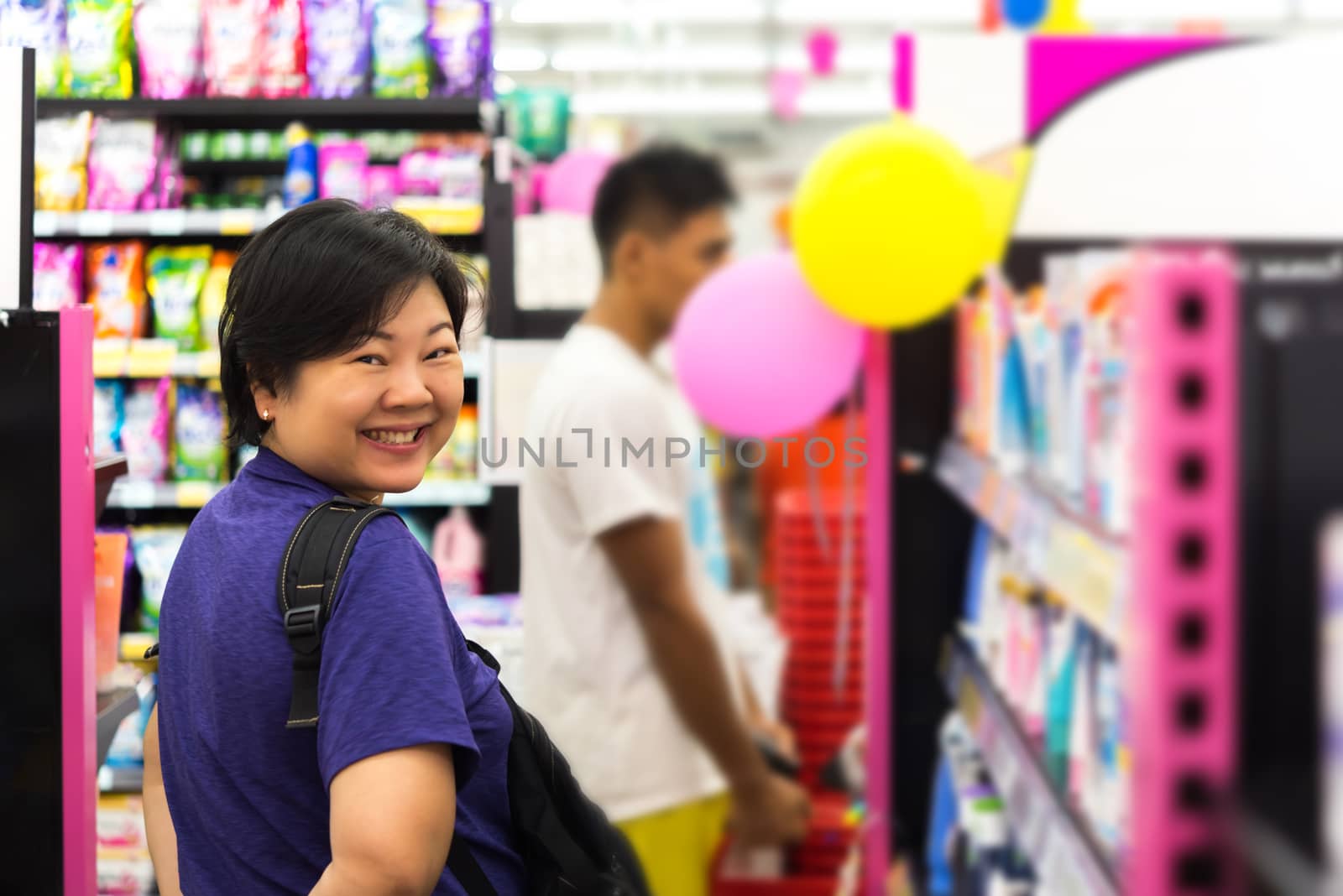 Asian woman with many types of cosmetics for beauty and skin health products for sale in supermarket open daily