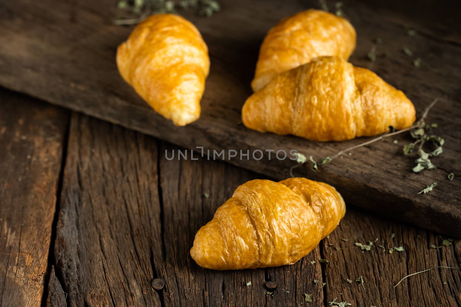 Coffee and croissants on the wooden background, top view