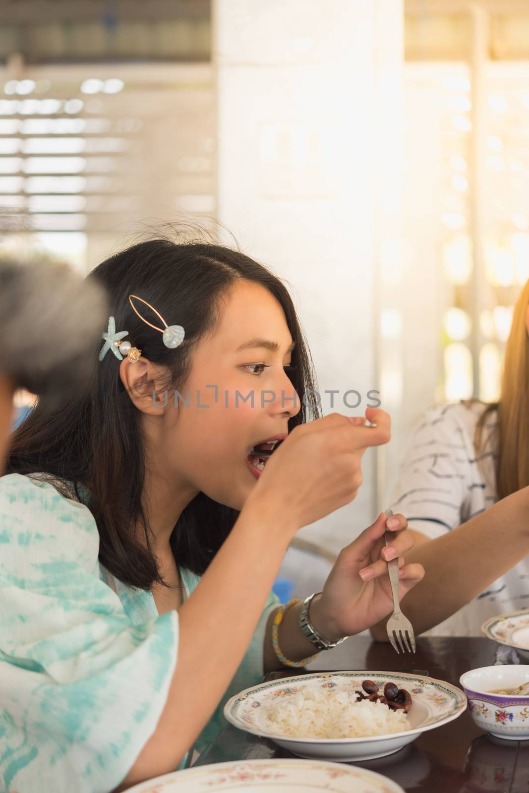 Woman eating food on dining table in restaurant by PongMoji