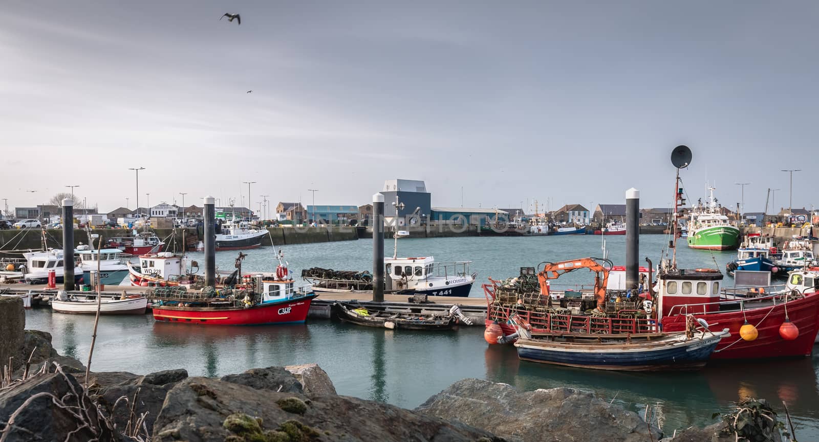 Howth near Dublin, Ireland - February 15, 2019: view of the fishing port of the city where are parked professional fishing boats on a winter day