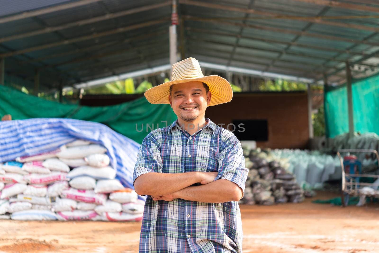 Asian man farmer agriculturist happy at a Fertilizer composting plant with Organic Fertilizer, Compost (Aerobic Microorganisms) from animal waste for use in the organic agriculture industry