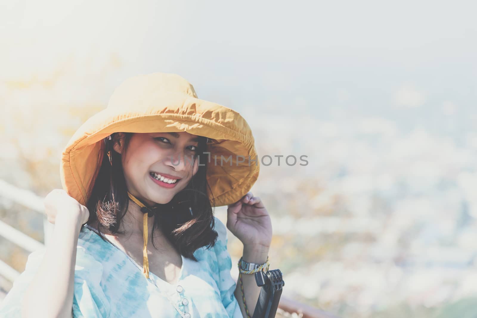 Asian pretty cute woman with hat relax at seaside city landscape viewpoint on mountain with happy and freedom emotion in concept travel, vacation, leisure in life