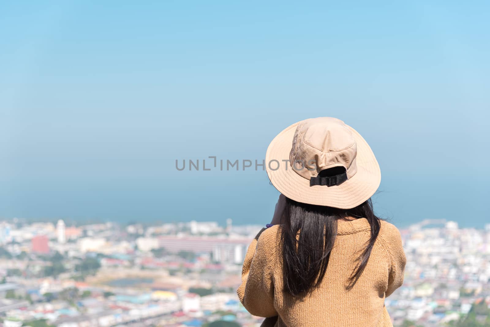 Asian pretty cute woman with hat relax at seaside city landscape viewpoint on mountain with happy and freedom emotion in concept travel, vacation, leisure in life