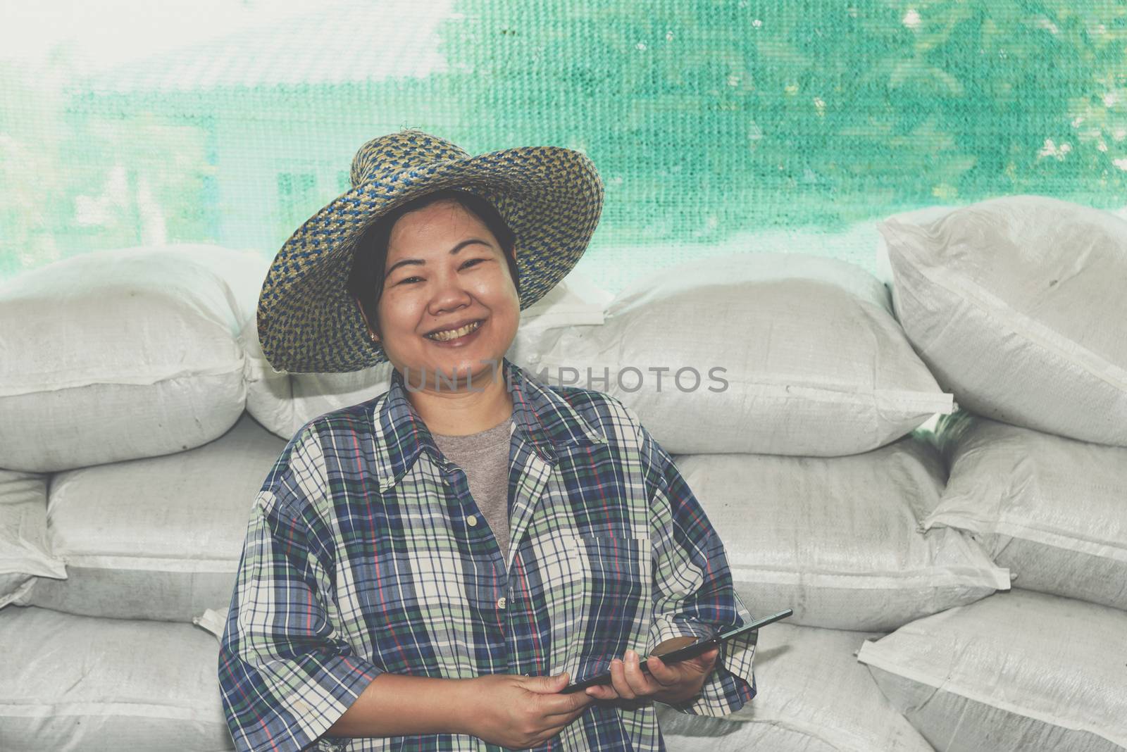 Asian woman smart farmer agriculturist happy at a Fertilizer composting plant with Organic Fertilizer, Compost (Aerobic Microorganisms) from animal waste for use in the organic agriculture industry