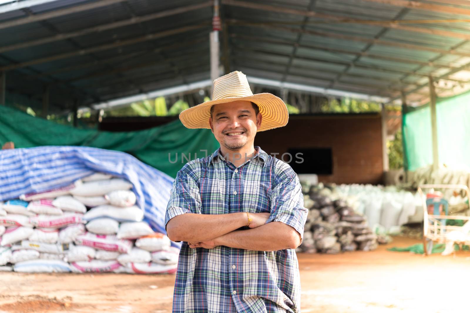 Asian man farmer agriculturist happy at a Fertilizer composting plant with Organic Fertilizer, Compost (Aerobic Microorganisms) from animal waste for use in the organic agriculture industry