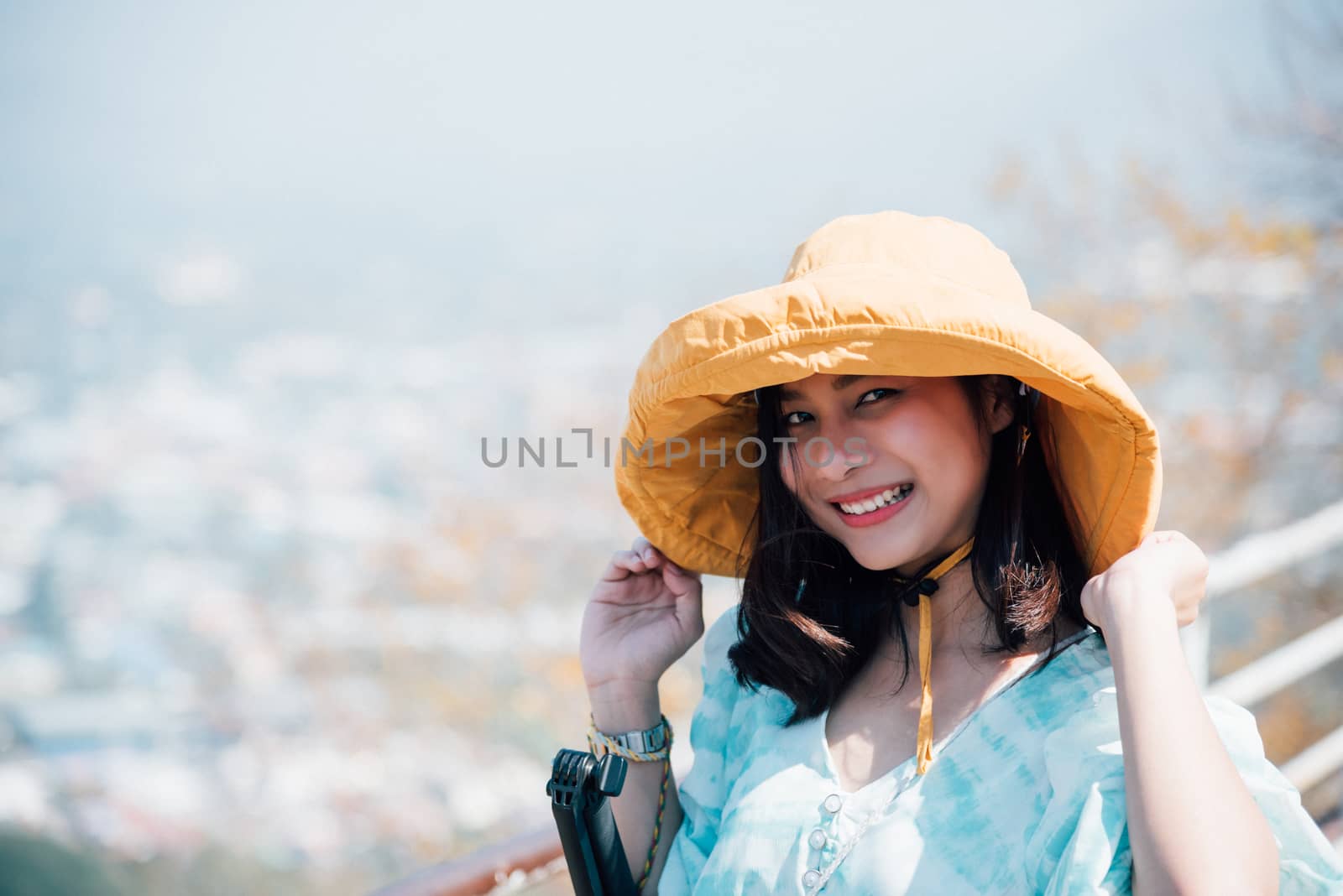 Asian pretty cute woman with hat relax at seaside city landscape viewpoint on mountain with happy and freedom emotion in concept travel, vacation, leisure in life