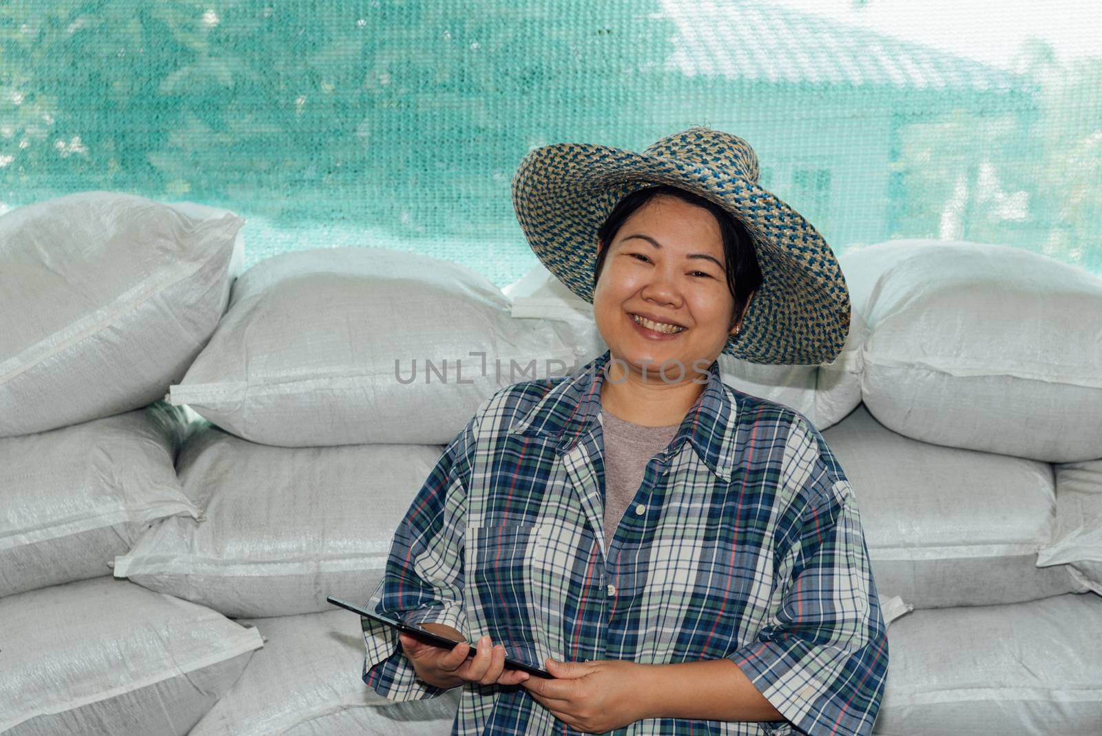 Asian woman smart farmer agriculturist happy at a Fertilizer composting plant with Organic Fertilizer, Compost (Aerobic Microorganisms) from animal waste for use in the organic agriculture industry