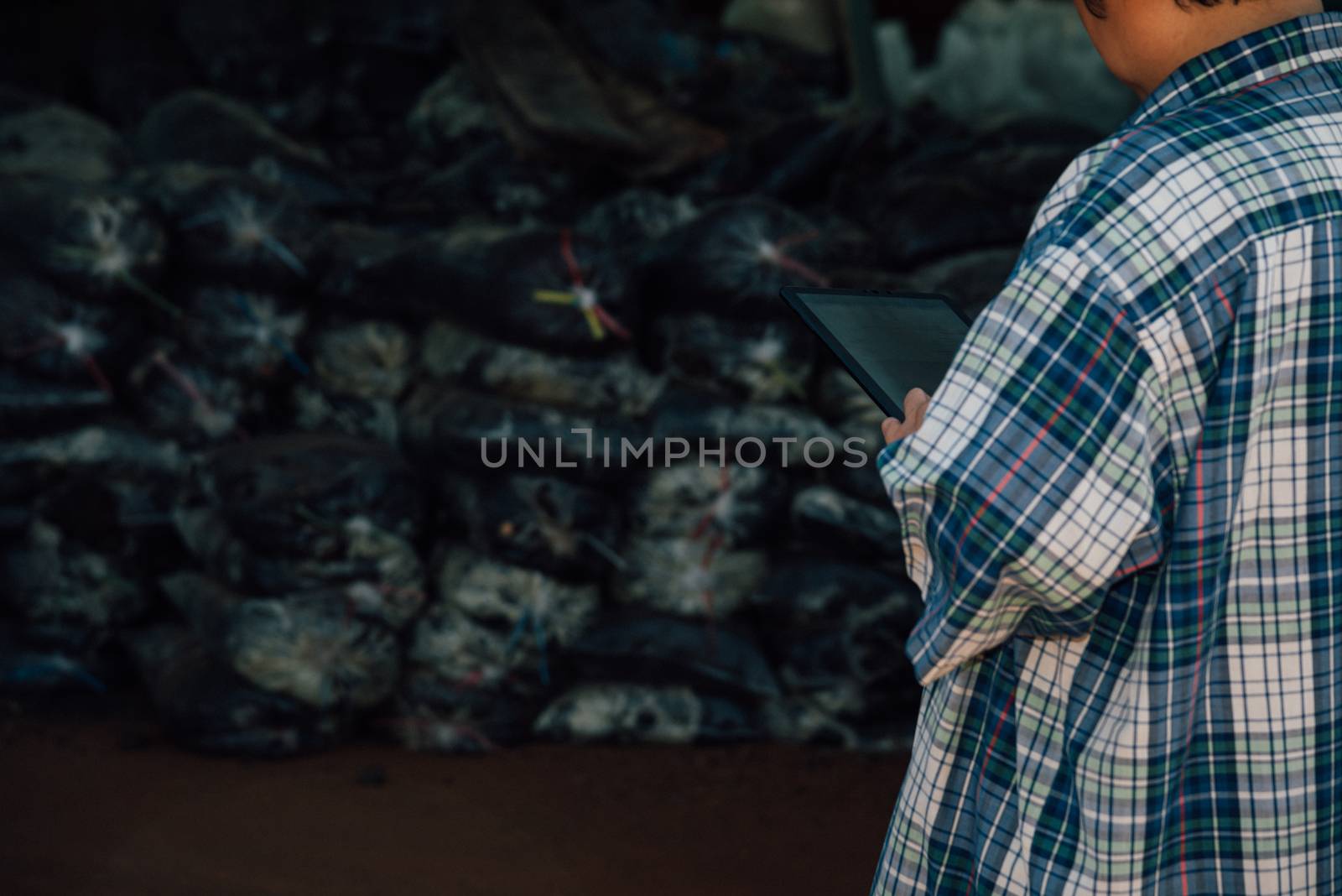 Asian woman smart farmer agriculturist happy at a Fertilizer composting plant with Organic Fertilizer, Compost (Aerobic Microorganisms) from animal waste for use in the organic agriculture industry