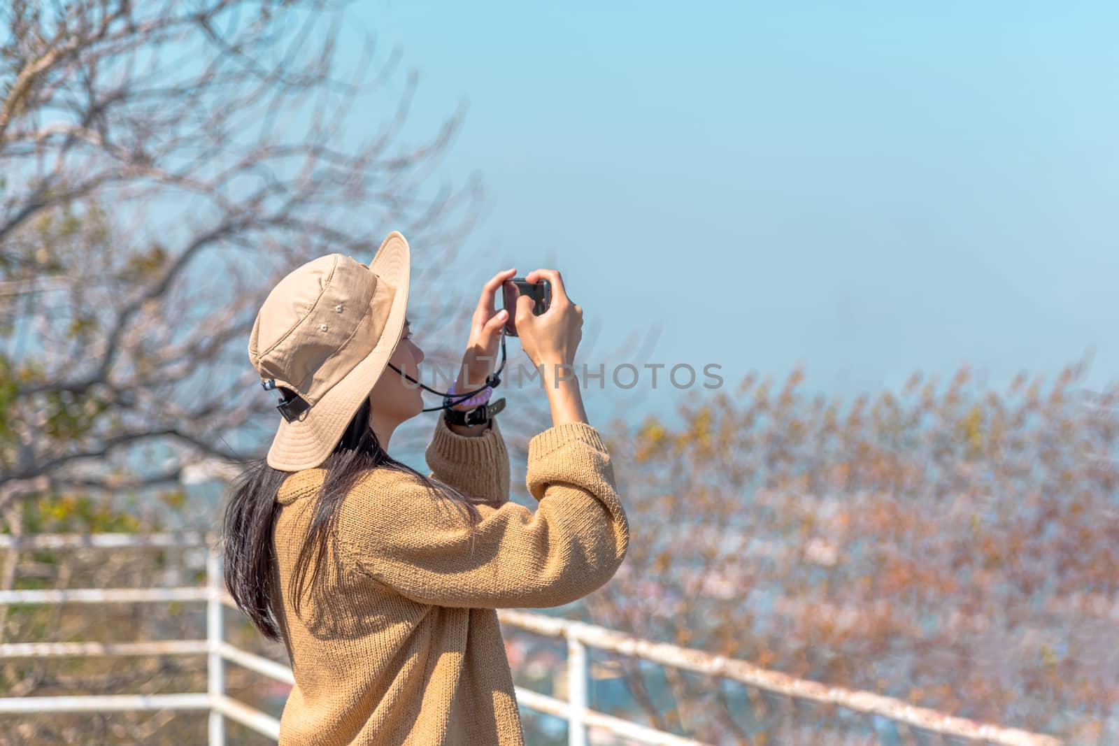 Asian pretty cute woman with hat relax and use smartphone at seaside city landscape viewpoint on mountain with happy and freedom emotion in concept travel, vacation, leisure in life